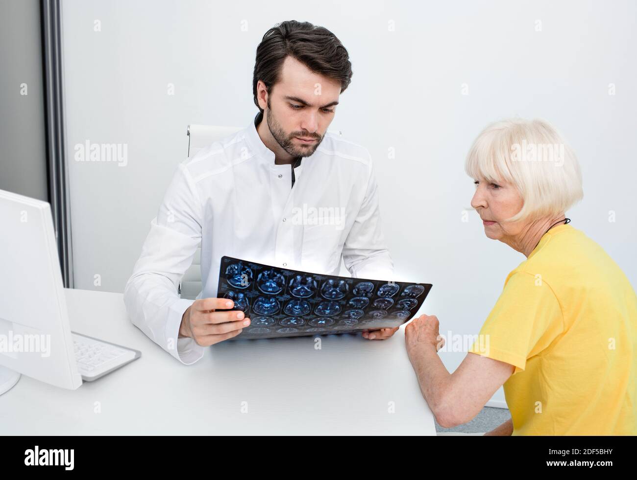doctor analyzing the results MRI brain of an elderly woman. Diagnosis of diseases and head injuries. Headache treatment Stock Photo