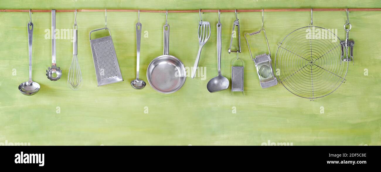 restaurant kitchen utensils on green painted wall, free copy space Stock Photo