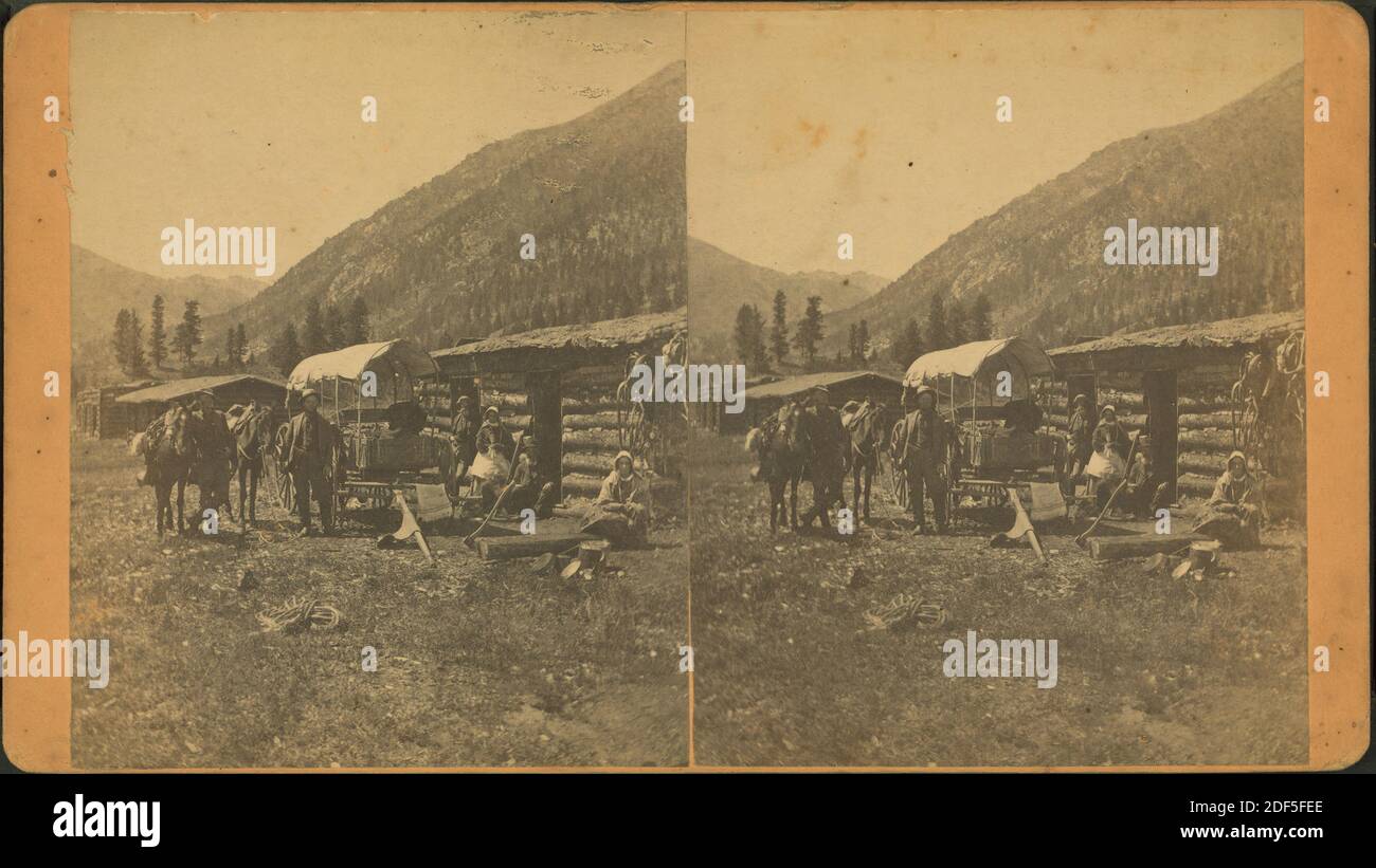 Group in front of a log cabin with a covered wagon., still image, Stereographs, 1850 - 1930, Talbot, C. W Stock Photo