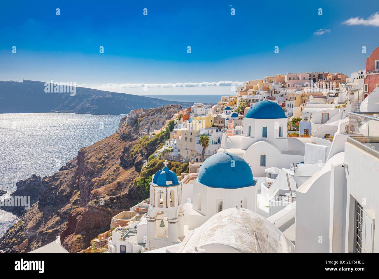 Beautiful Oia town on Santorini island, Greece. Traditional white architecture and greek orthodox churches with blue domes over Caldera, Aegean sea Stock Photo