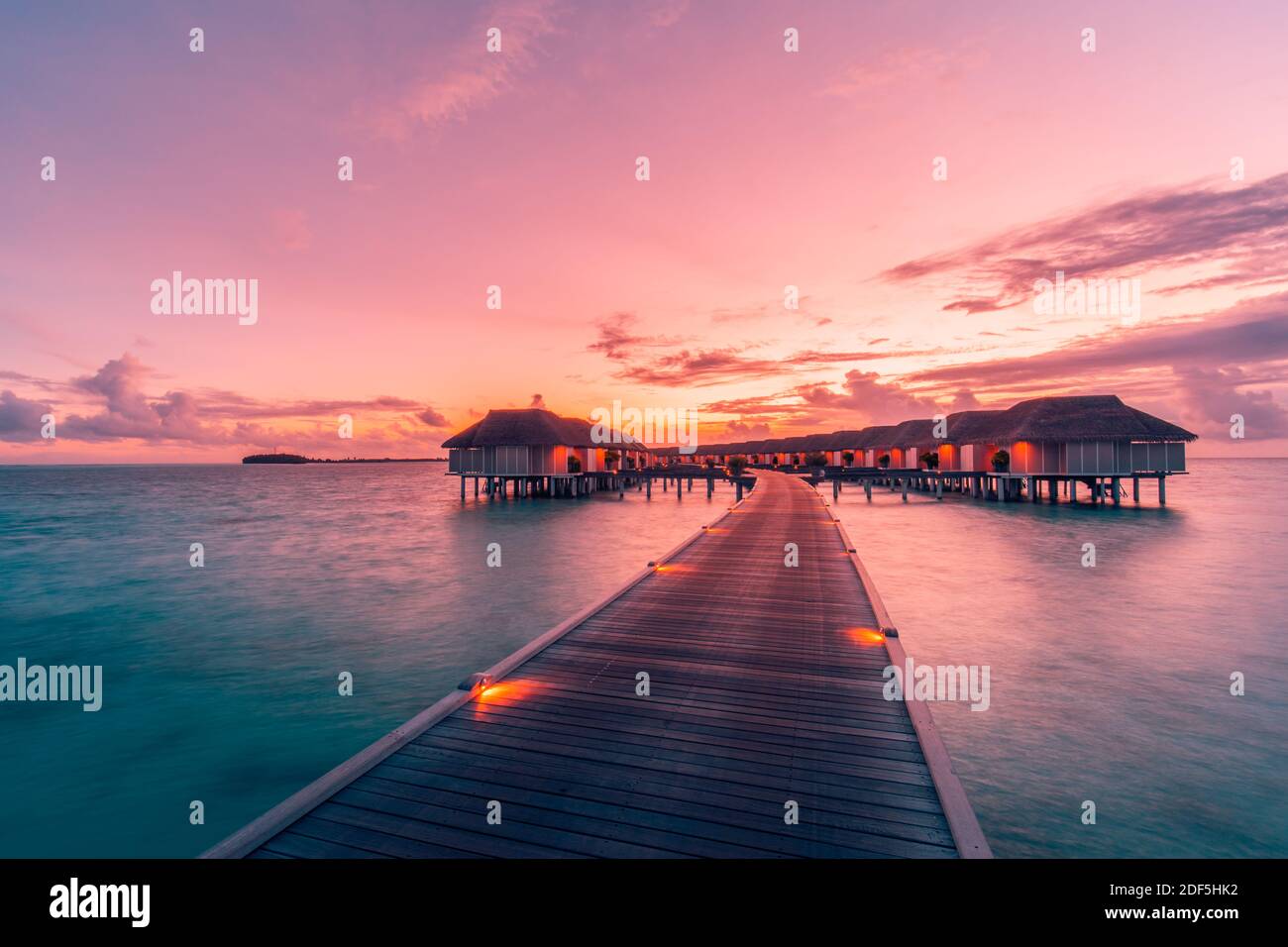 Sunset on Maldives island, luxury water villas resort and wooden pier