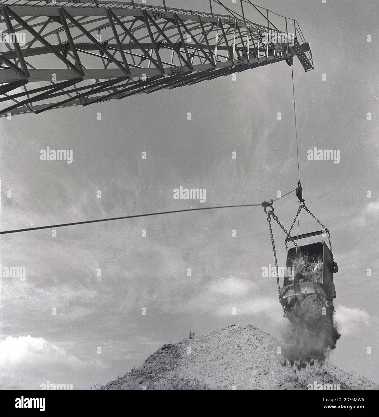 1950s, historical, seen from below, a dragline excavator in action at a