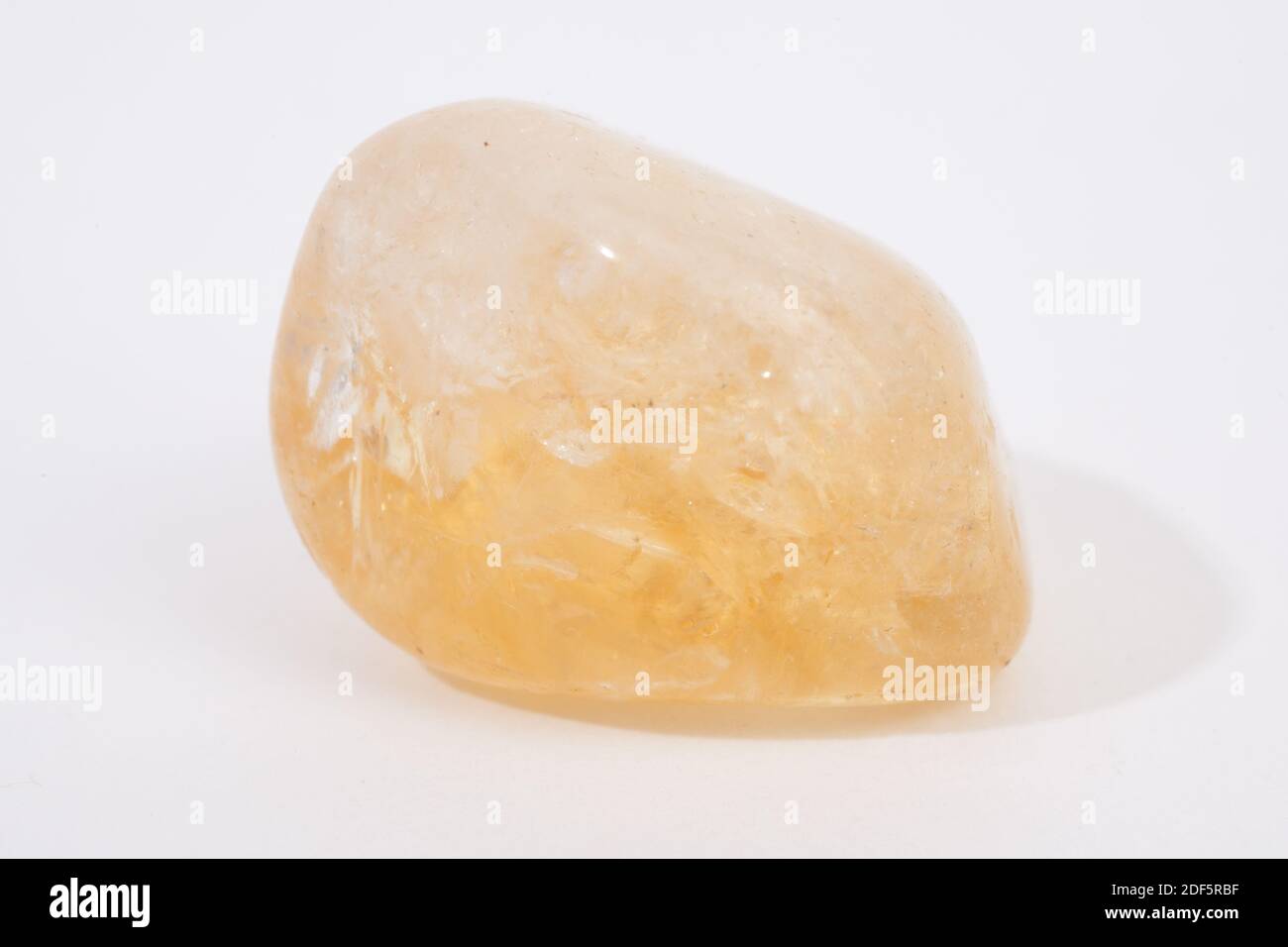 A citrine gemstone isolated against a white studio backdrop Stock Photo