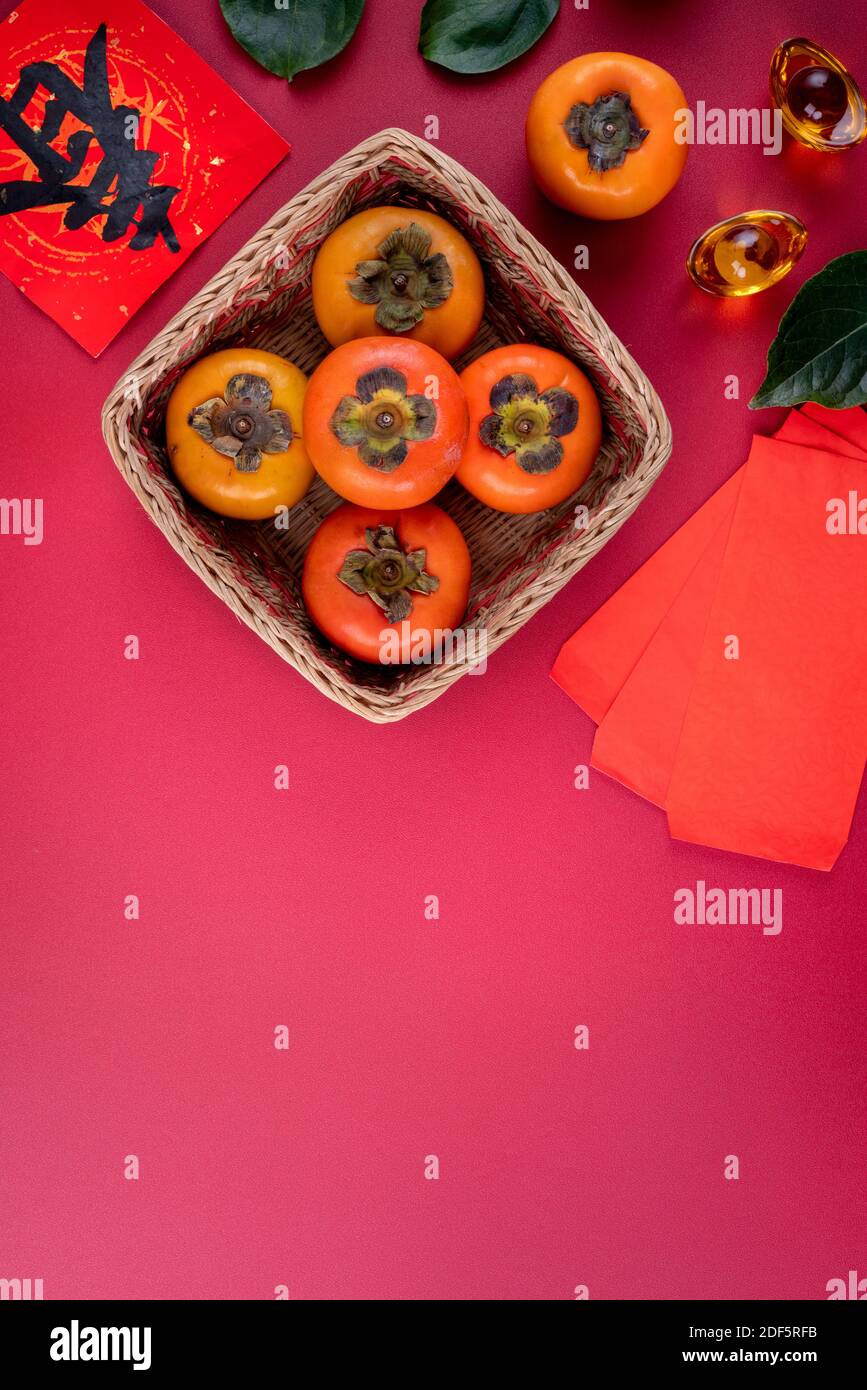 Top view of fresh sweet persimmons kaki with leaves on red table