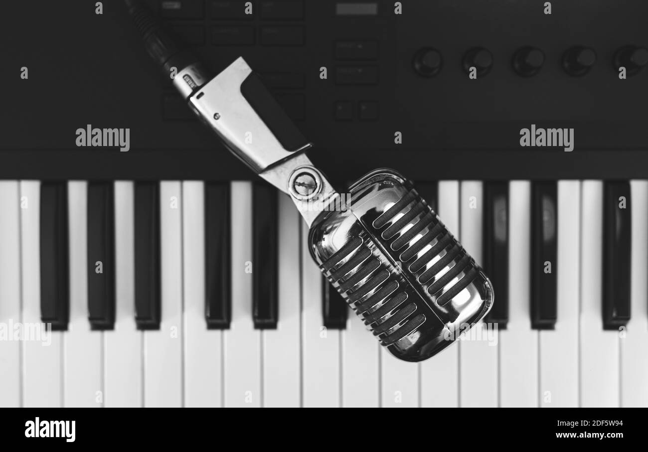 Microphone on the piano keyboard. Recording studio concept. Stock Photo