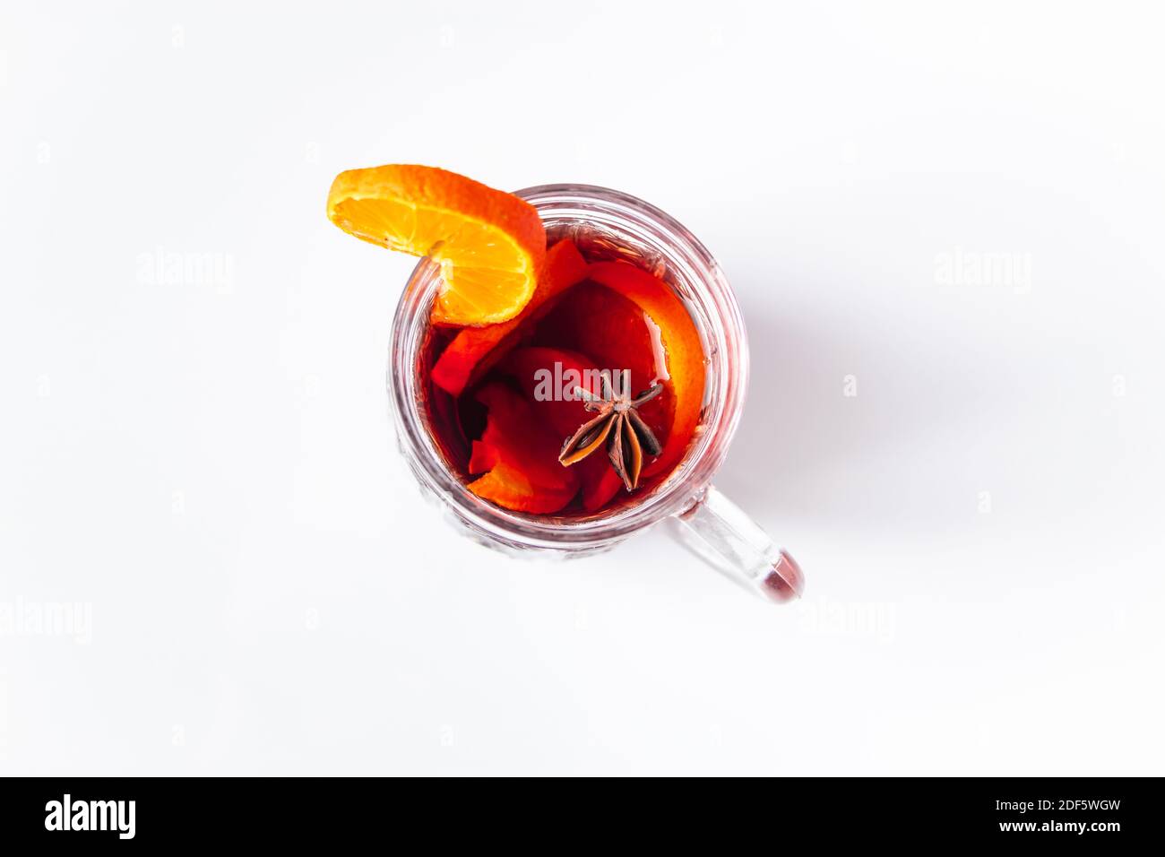 Glass cup with mulled wine on white background. Winter warming drink. Stock Photo