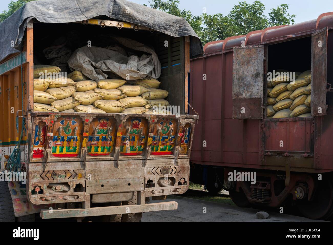 Bags of cement loaded manually from train to waiting lorry for further distribution in Mathura, Uttar Pradesh, India. Stock Photo