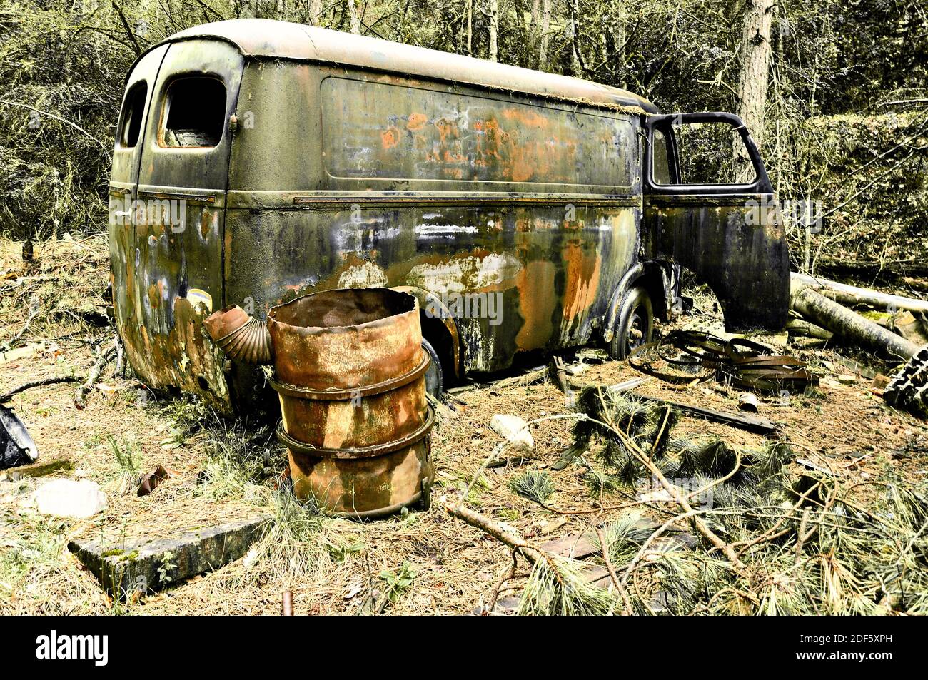 Abandoned rusty car and barrel left in the forest. France Stock Photo ...