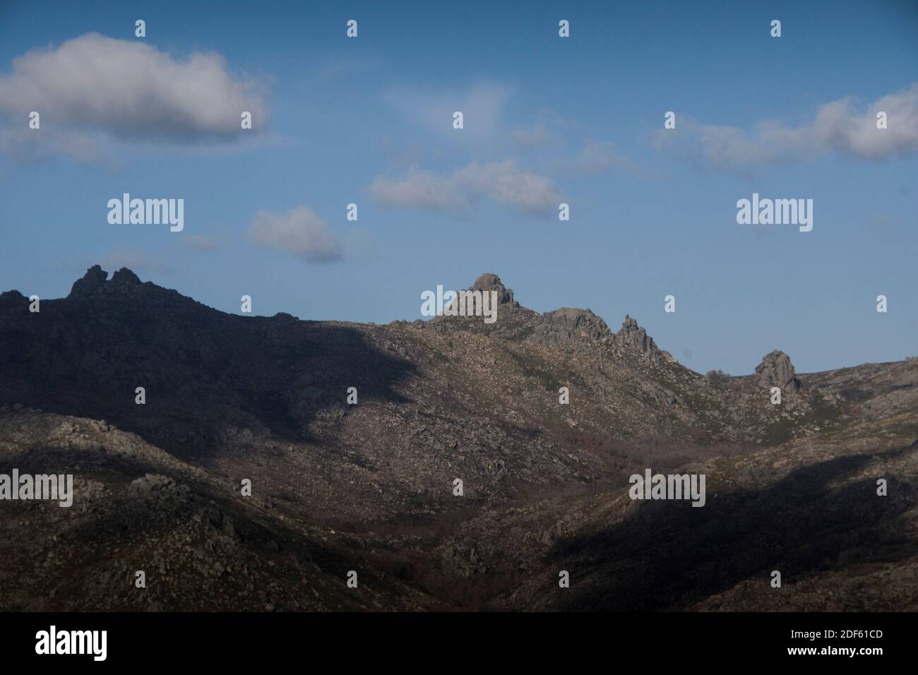 Mountain rocky landscape in a sunny autumn day, as the shadow from the clouds cover the landscape rocky peaks Stock Photo