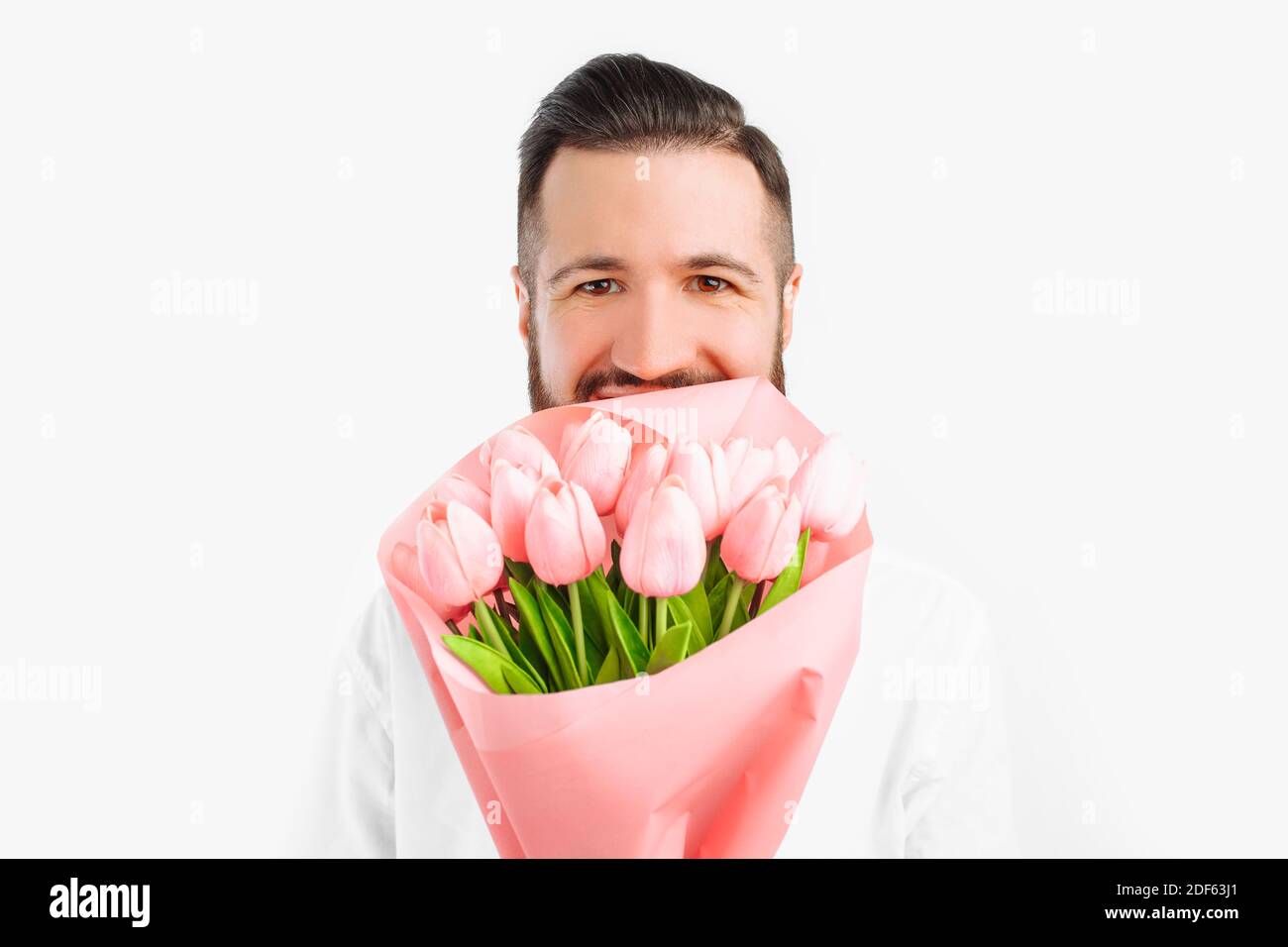 Elegant man with a beard holding a bouquet of tulips, a gift for ...