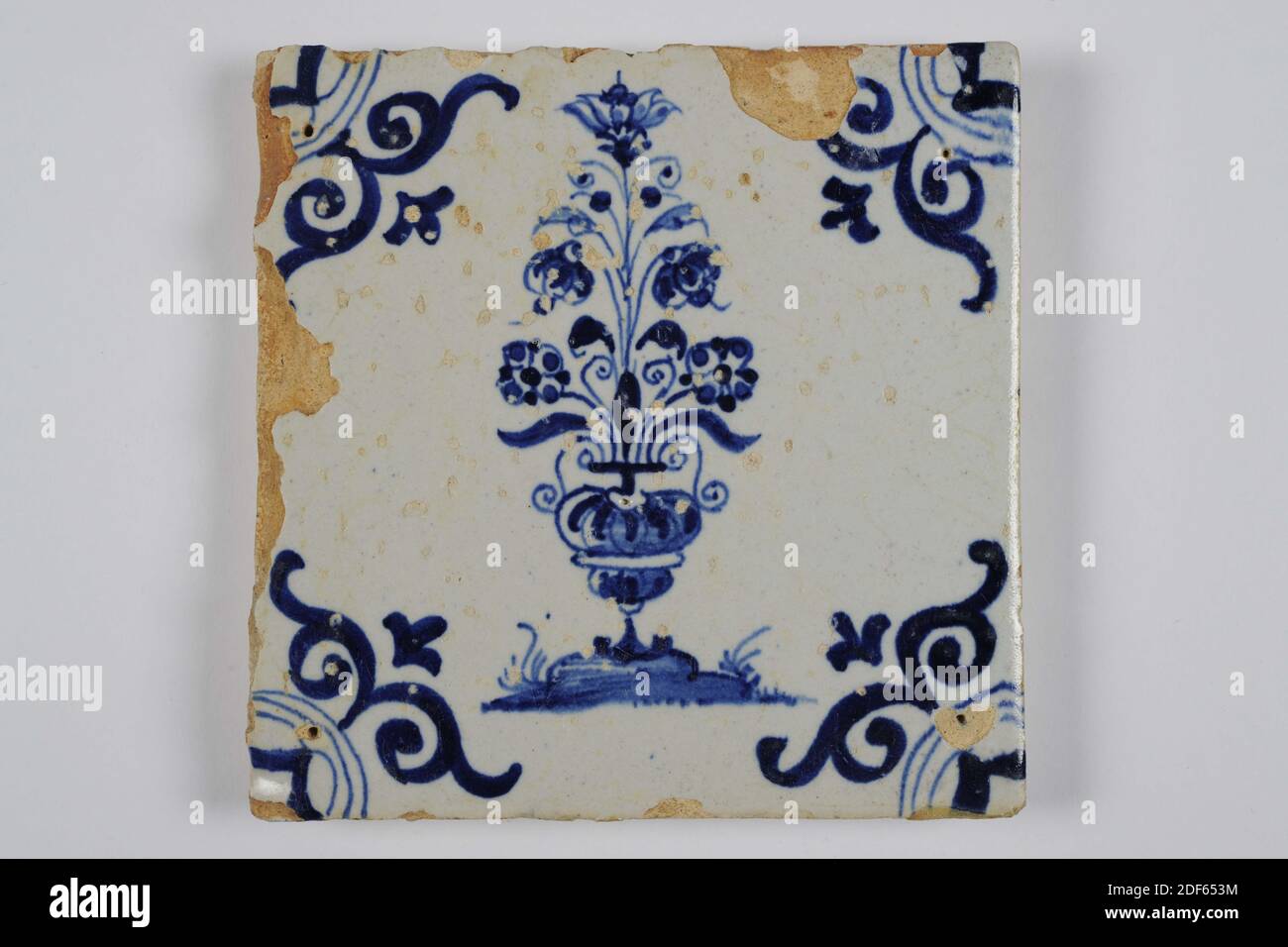wall tile, Anonymous, first half of the 17th century, tin glaze, earthenware, General: 13.5 x 13.4 x 1.5cm (135 x 134 x 15mm), flower pot, flower, northern Netherlands, Earthenware wall tile covered with tin glaze and painted in blue. The tile depicts a flower pot with a tall bouquet of five flowers. The tile has an ox head as a corner motif. On the back the painting of a monogram CIV and one corner filling of the ox head in blue, 1985 Stock Photo