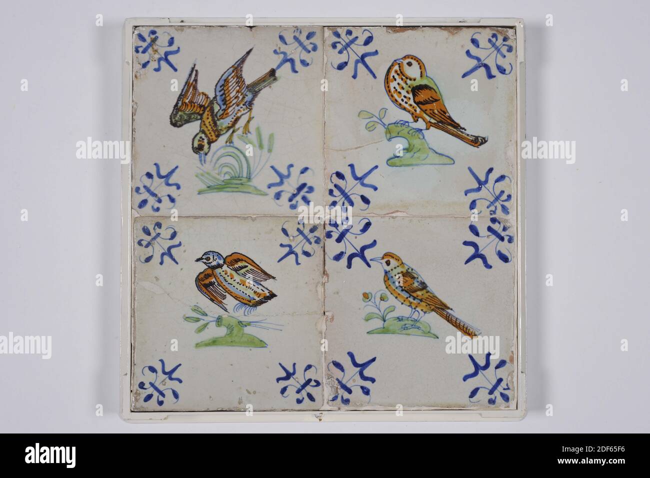 tile field, Anonymous, between 1620 - 1650, tin glaze, pottery, With frame: 16 x 54.7 x 3.6cm (160 x 547 x 36mm), bird, Tile field of four tiles (one by four) of earthenware covered with tin glaze. Multicolor painted in blue, green and orange. On each tile is a bird centered to the left, always on a light green ground with an orange spot and a light green branch. The birds from left to right: 1: profile profiled to the left in blue, orange and green, 2: profile profiled to the left with a long neck, head turned to the right, 3: profile profiled to the left in blue, orange and green, with short Stock Photo