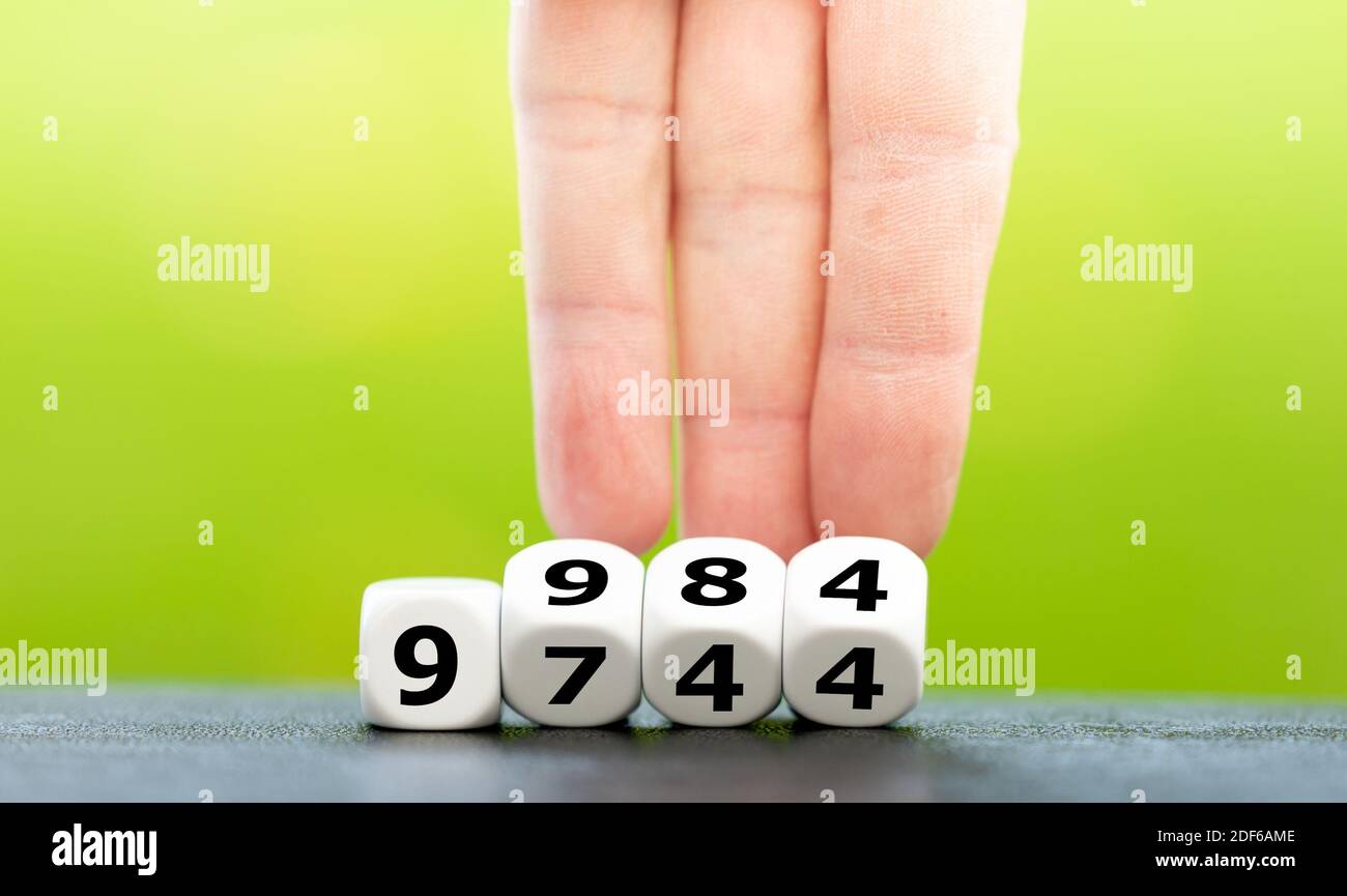 Symbol for the increase of the personal exemption in Germany. Hand turns dice and changes the amount 9744 Euro to 9984 Euro. Stock Photo