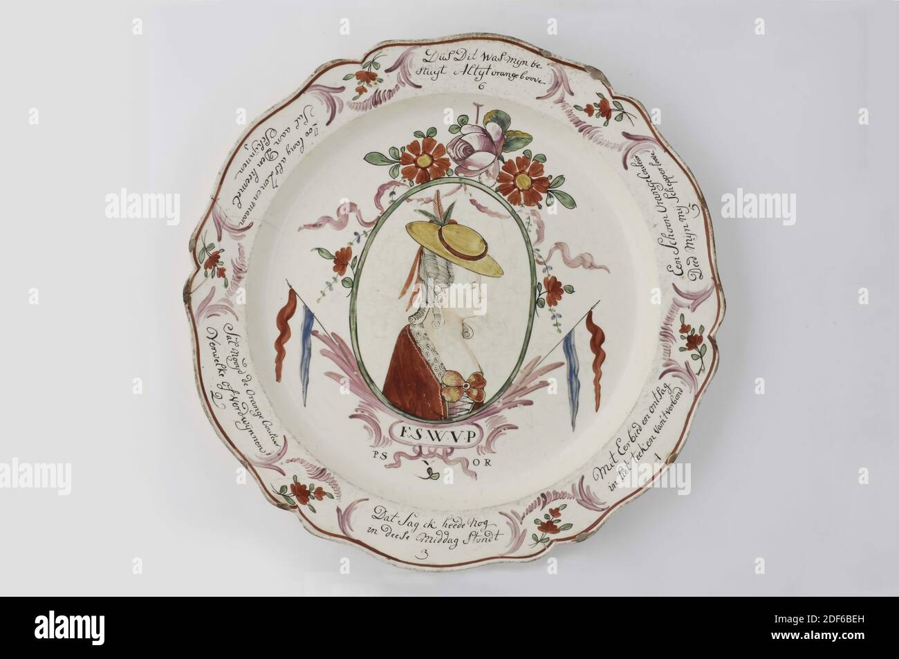 plate (crockery), Anonymous, c. 1790, glaze, earthenware, General: 39.5 x 4.1cm (395 x 41mm), Dish of English creamware with a flat bottom, a hollow wall and a scalloped, protruding rim. Decorated in the center with a portrait of Wilhelmina of Prussia in an oval medallion with a Dutch flag on both sides and a floral top with ribbon on top. Under the portrait the inscription F.S.W.V.P PS V OR. On the rim six verses of a verse in black writing, separated by a simple floral pattern: As long as Sun and Moon | Sal in the sky Shine 1, Sal nooyd de Orange Couleur | Fade or disappear 2, That Sag I had Stock Photo
