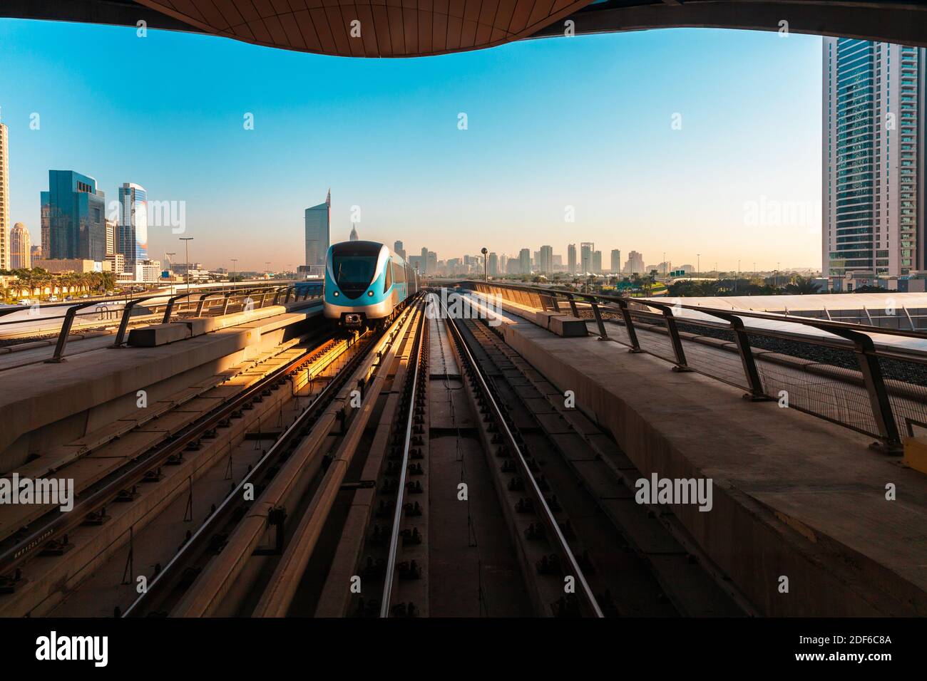 View of the train and the Dubai downtown skyline from a metro station, Dubai, UAE Stock Photo