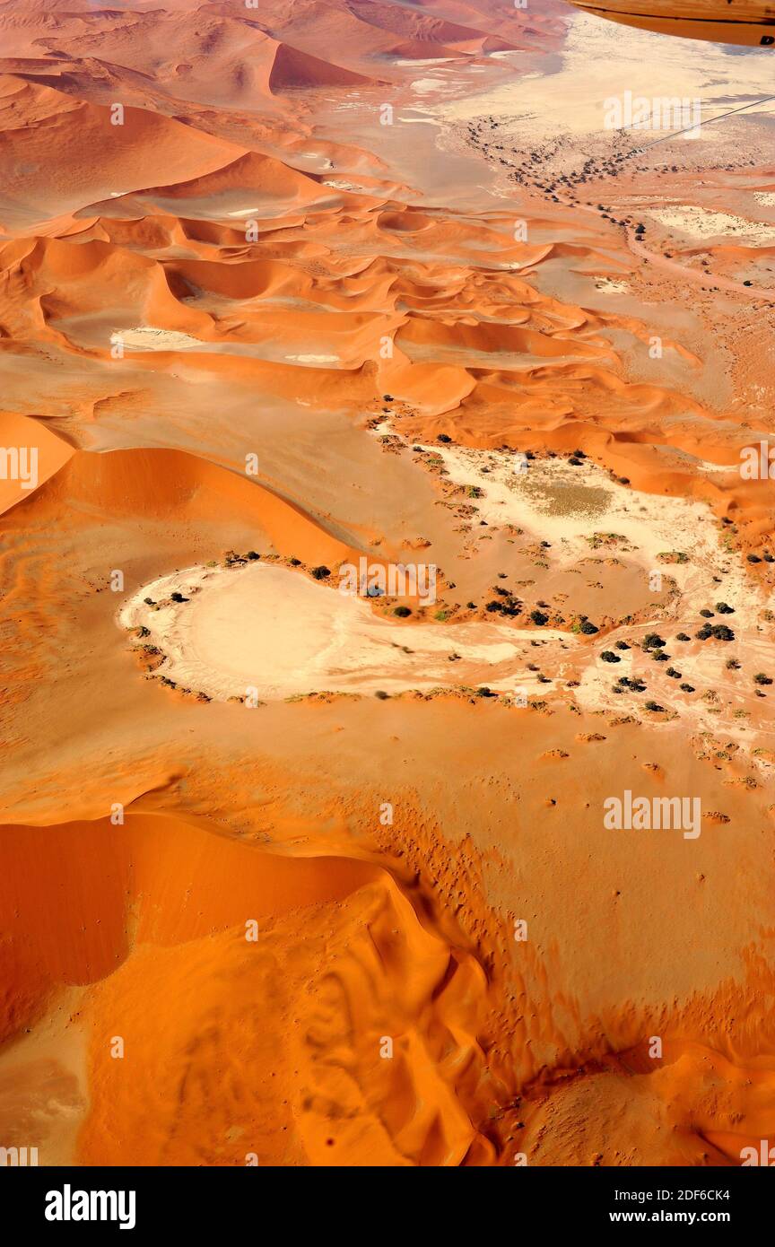 Aerial photography of Namib desert dunes with pans (endorheic drainage basins) produced by ephemeral Tsauchab River. Dune is a hill of loose sand Stock Photo