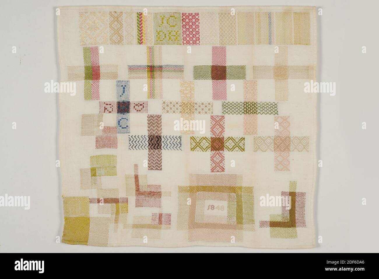 stoplap, J.C. de Haas, 1848, cotton, silk, General: 48 x 51cm (480 x 510mm), Stoplap of cotton with matting binding stopped with silk. The patch has various plugs and tapped edges in various colors and patterns. In the top edge the initials JCDH in green letters, in the bottom row in a rectangle the year 1848. The topstitches on the top row are mainly twill weave with fantasy patterns. The cross-caps underneath in check pattern twill, plain weave, eyelet twill, pointed twill and diamond twill. At the bottom there are various snags and a rectangular cut-out piece of fabric Stock Photo