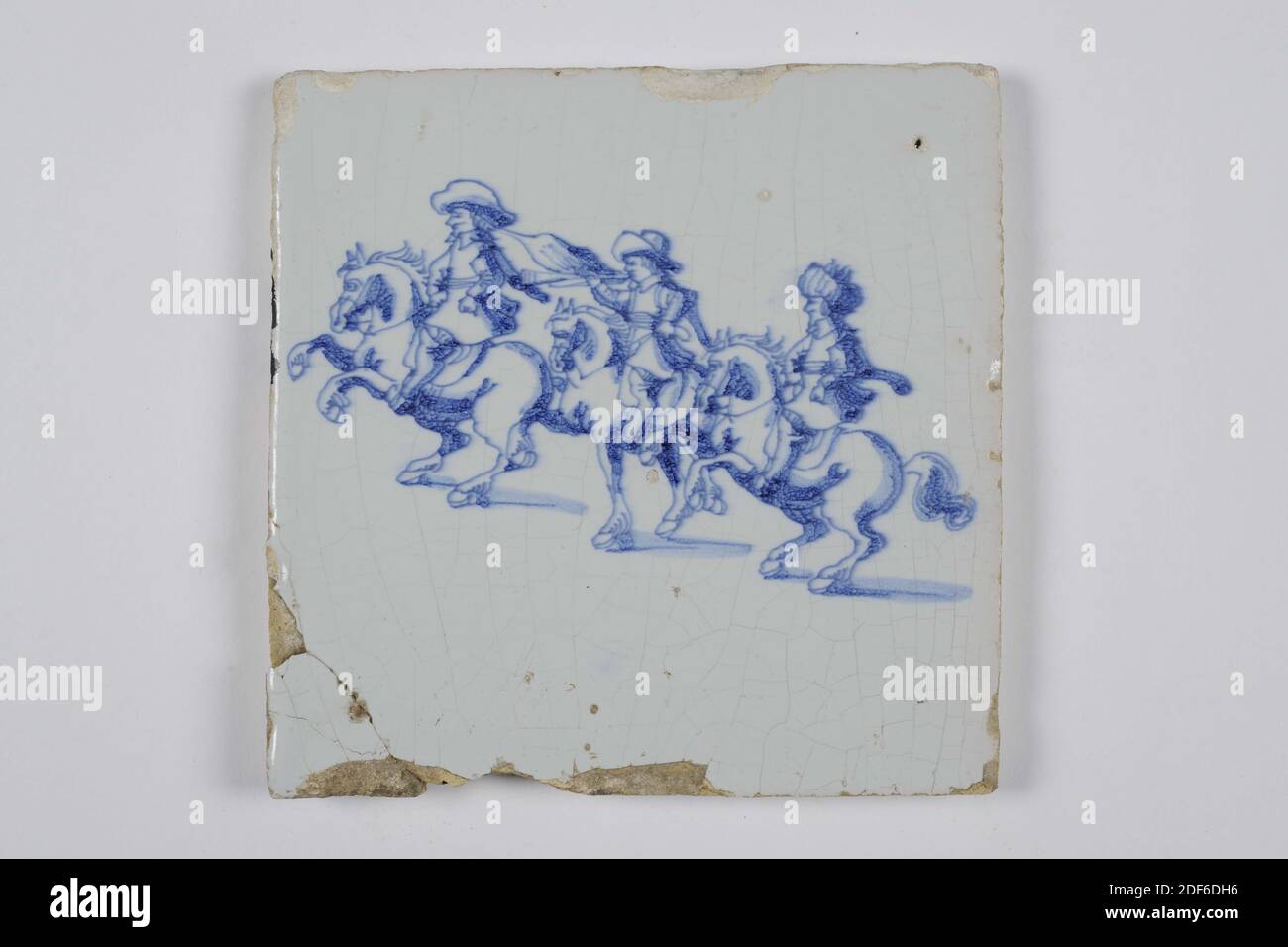 wall tile, Anonymous, 18th century, tin glaze, earthenware, General: 13 x 13 x 1cm (130 x 130 x 10mm), horse, rider, northern netherlands, Earthenware wall tile covered in tin glaze painted in blue. On the tile, three horse riders are depicted on prancing horses. The riders wear hats and the middle rider blows a horn, 1985 Stock Photo