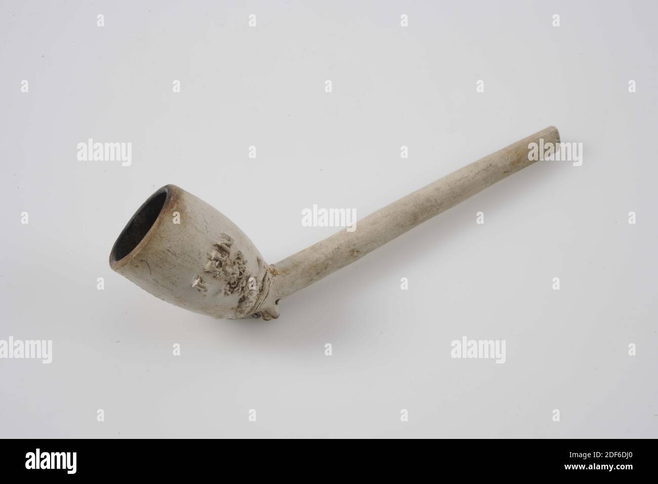 pipe (smoking utensils), Laurens Huijvenaar, 1760-1796, General: 3.9 x 2.7 x 11.6cm (39 x 27 x 116mm), fish, Tobacco pipe made of white pipe clay with embossed decoration on the head a sturgeon and three waves surmounted by a nine-pair crown and the letters IHN, 1938 Stock Photo