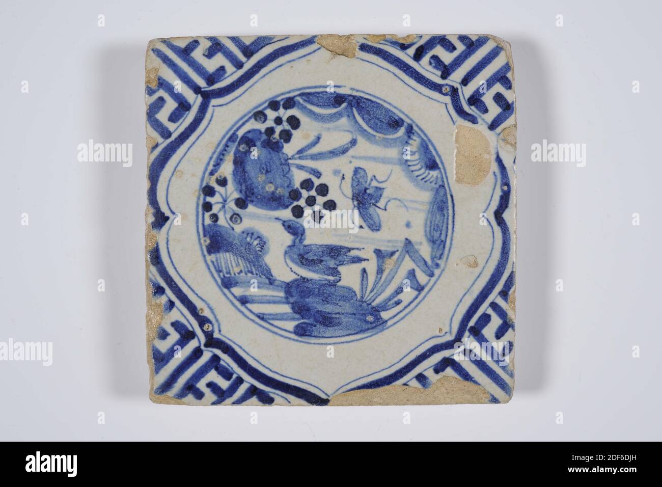 wall tile, Anonymous, first half 17th century, tin glaze, earthenware, General: 11 x 11 x 1.6cm (110 x 110 x 16mm), water surface, duck, insect, northern netherlands, Earthenware wall tile covered with tin glaze and painted in blue. The tile depicts a Chinoiserie representation of a duck and an insect in braces near a water surface. The tile has meanders as a corner motif, 1985 Stock Photo
