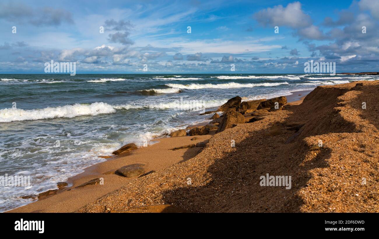 Rocky beach, small waves and blue sky with clouds Stock Photo - Alamy