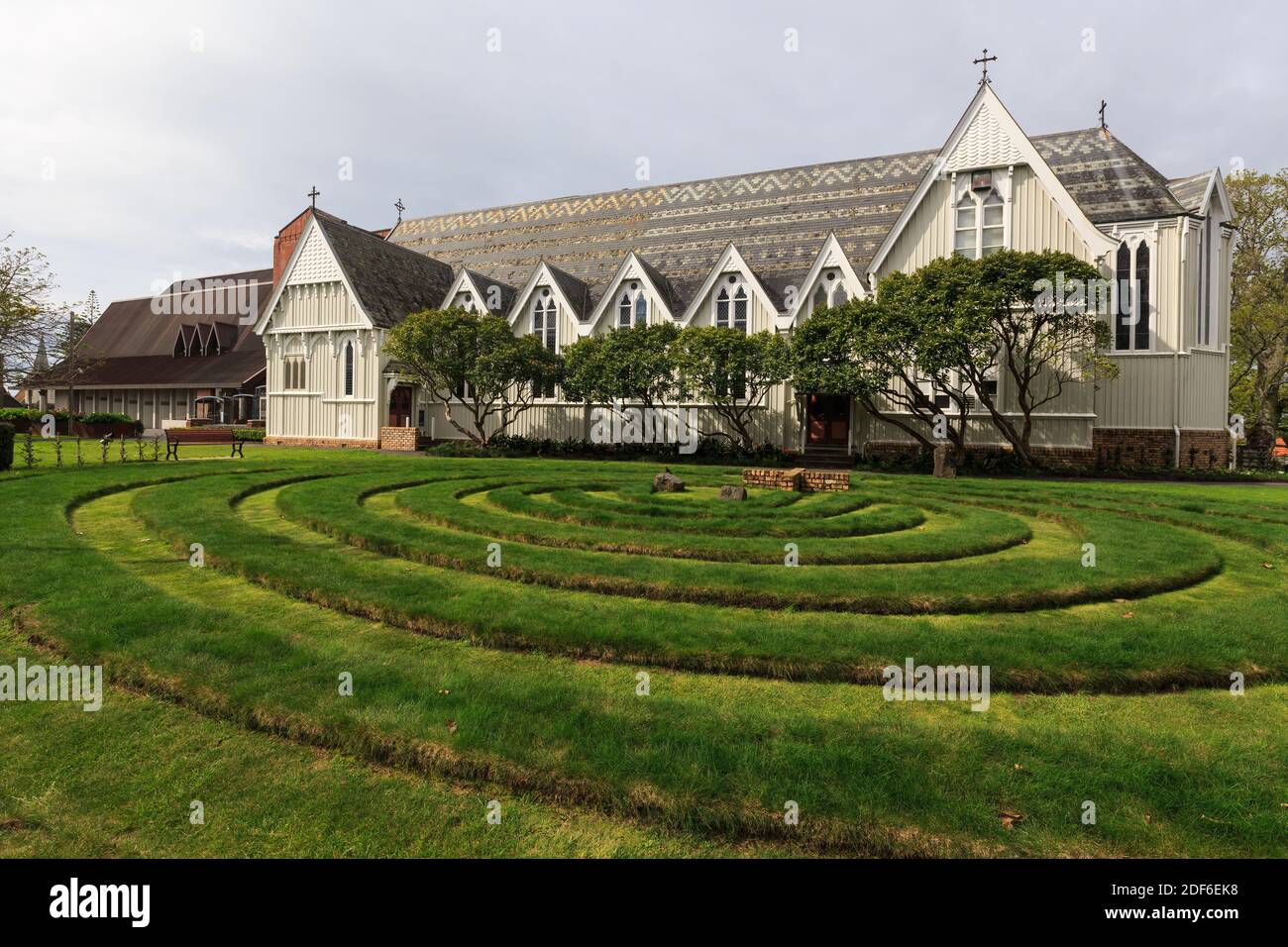 St. Mary's Church (1897), Parnell, Auckland, New Zealand, a former Anglican cathedral. The garden feature in the foreground is called the 'Labyrinth' Stock Photo
