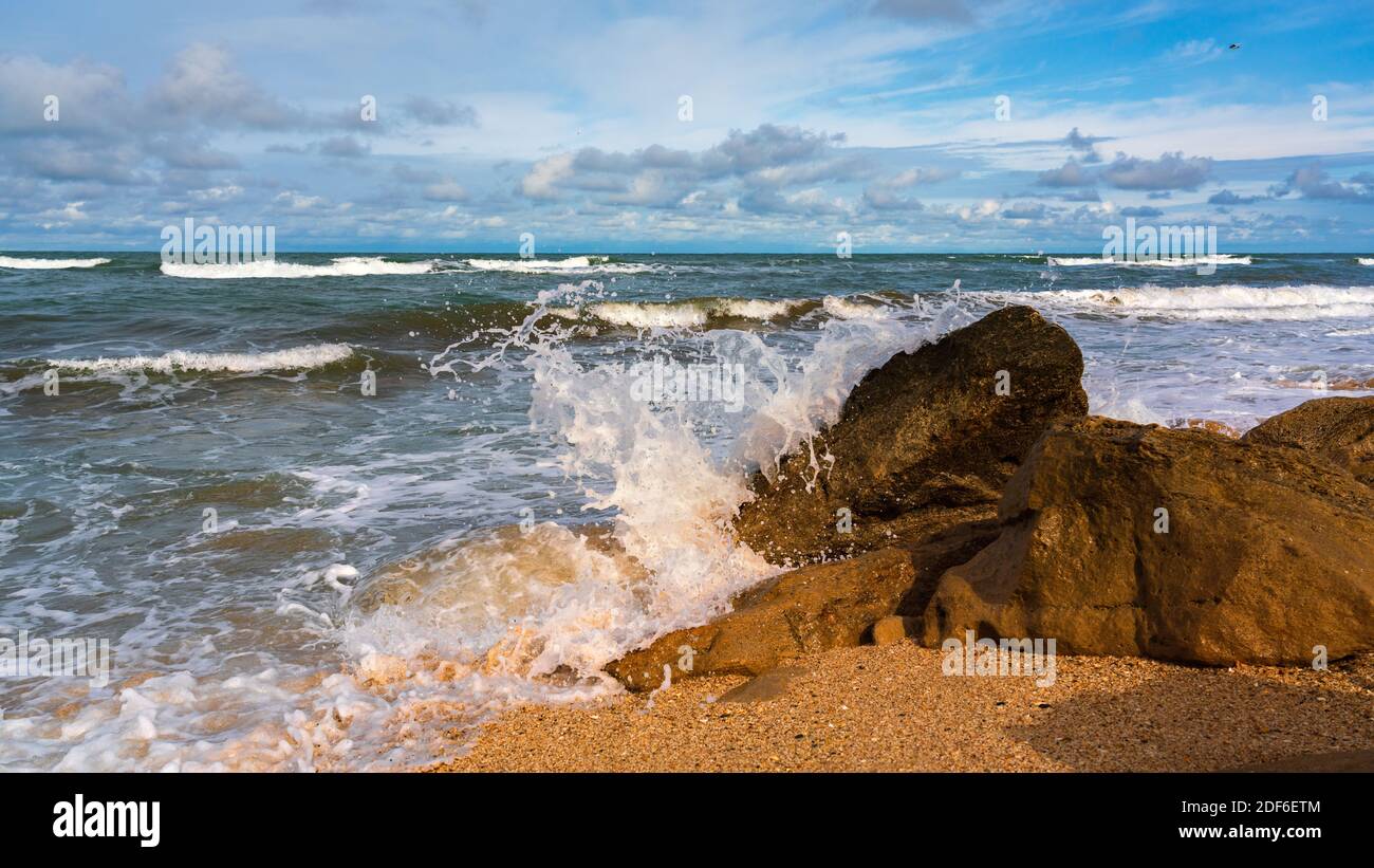 Rocky beach, small waves and blue sky with clouds Stock Photo - Alamy