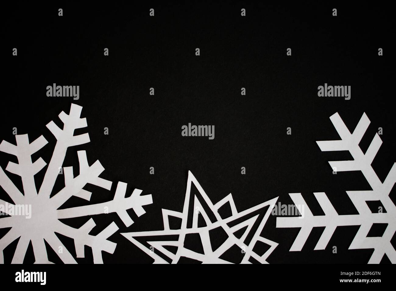 Cut out paper snowflakes on black background Stock Photo - Alamy