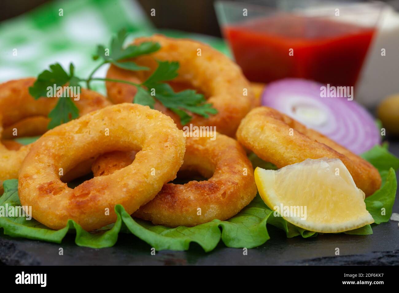 Deep fried squid or fish rings appetizer. Breaded squid or fish rings with  lemon, ketchup and tartar sauce. Close up of golden, crispy calamari snack  Stock Photo - Alamy