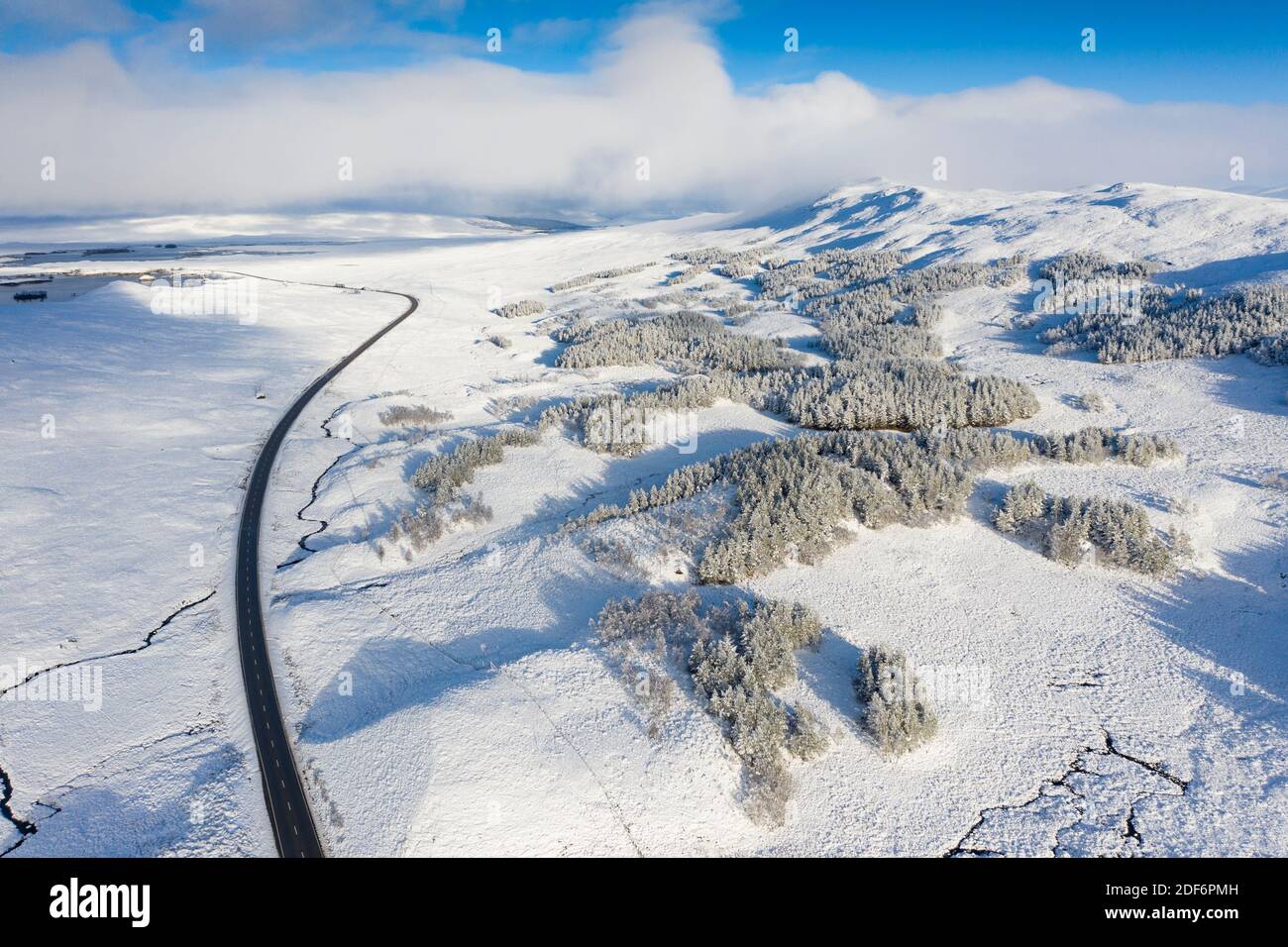 Glen Coe, Scotland, UK. 3 December 2020. A cold front has brought the first snowfall to the Scottish Highlands. Rannoch Moor and Glen Coe are covered in several inches of snow. Bright sunshine throughout the day created beautiful winter landscapes.  Pictured; Aerial view of A82 passing over snow covered Rannoch Moor.  Iain Masterton/Alamy Live News Stock Photo