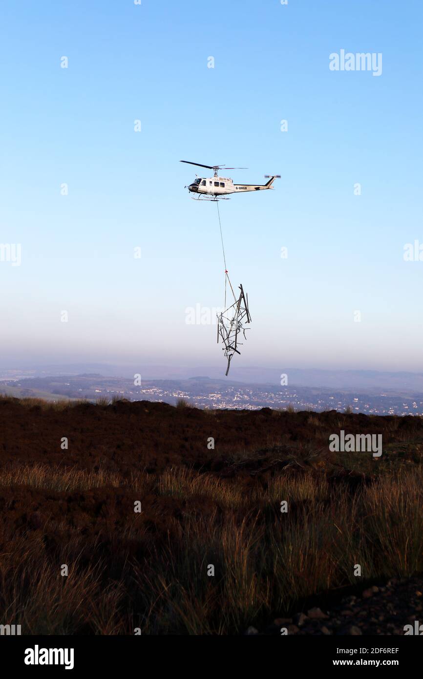 Helicopter transporting pieces of dismantled pylon across Clyde Muirshiel Regional Country ParkPark in Renfrewshire Scotland Stock Photo