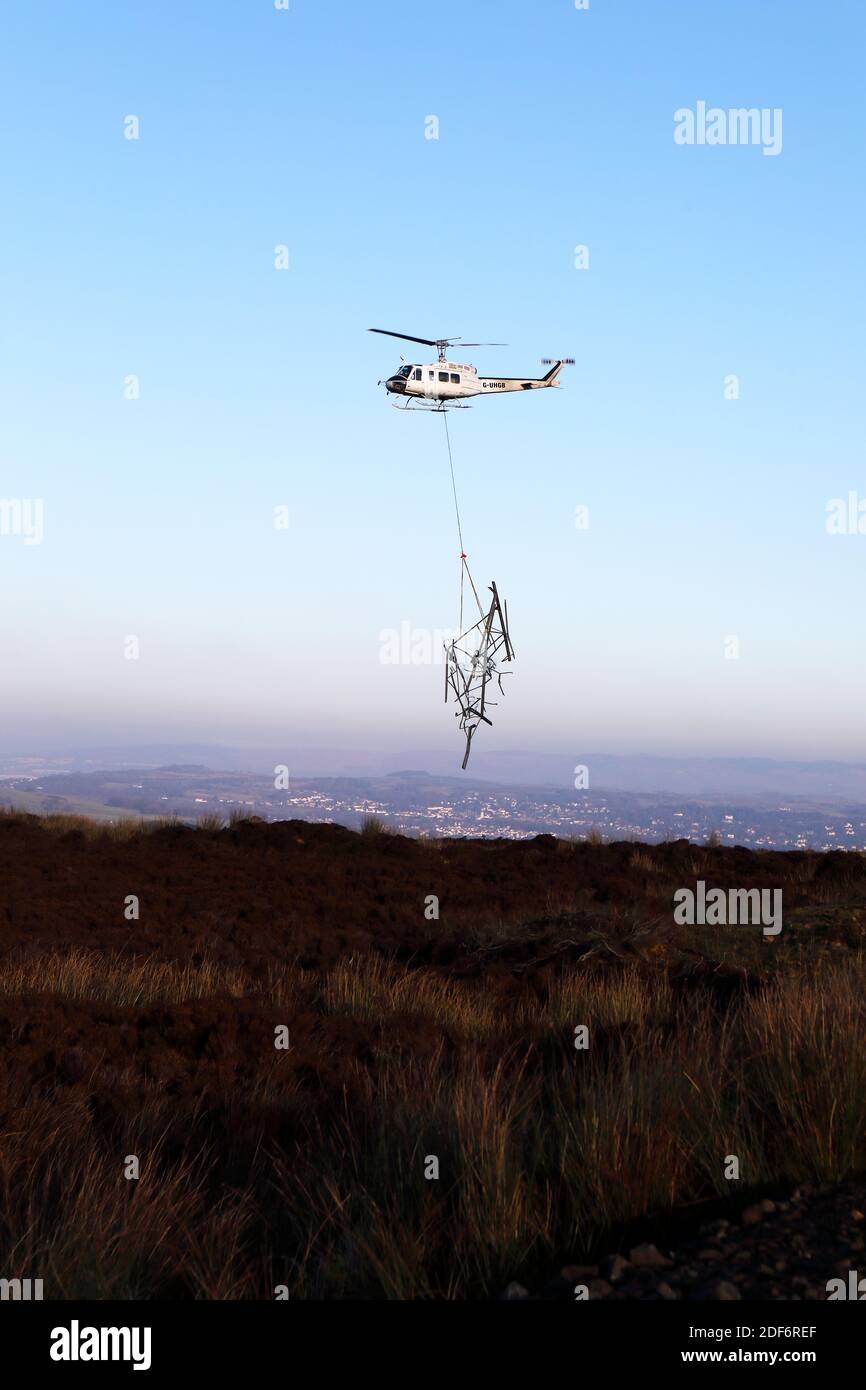 Helicopter transporting pieces of dismantled pylon across Clyde Muirshiel Regional Country ParkPark in Renfrewshire Scotland Stock Photo