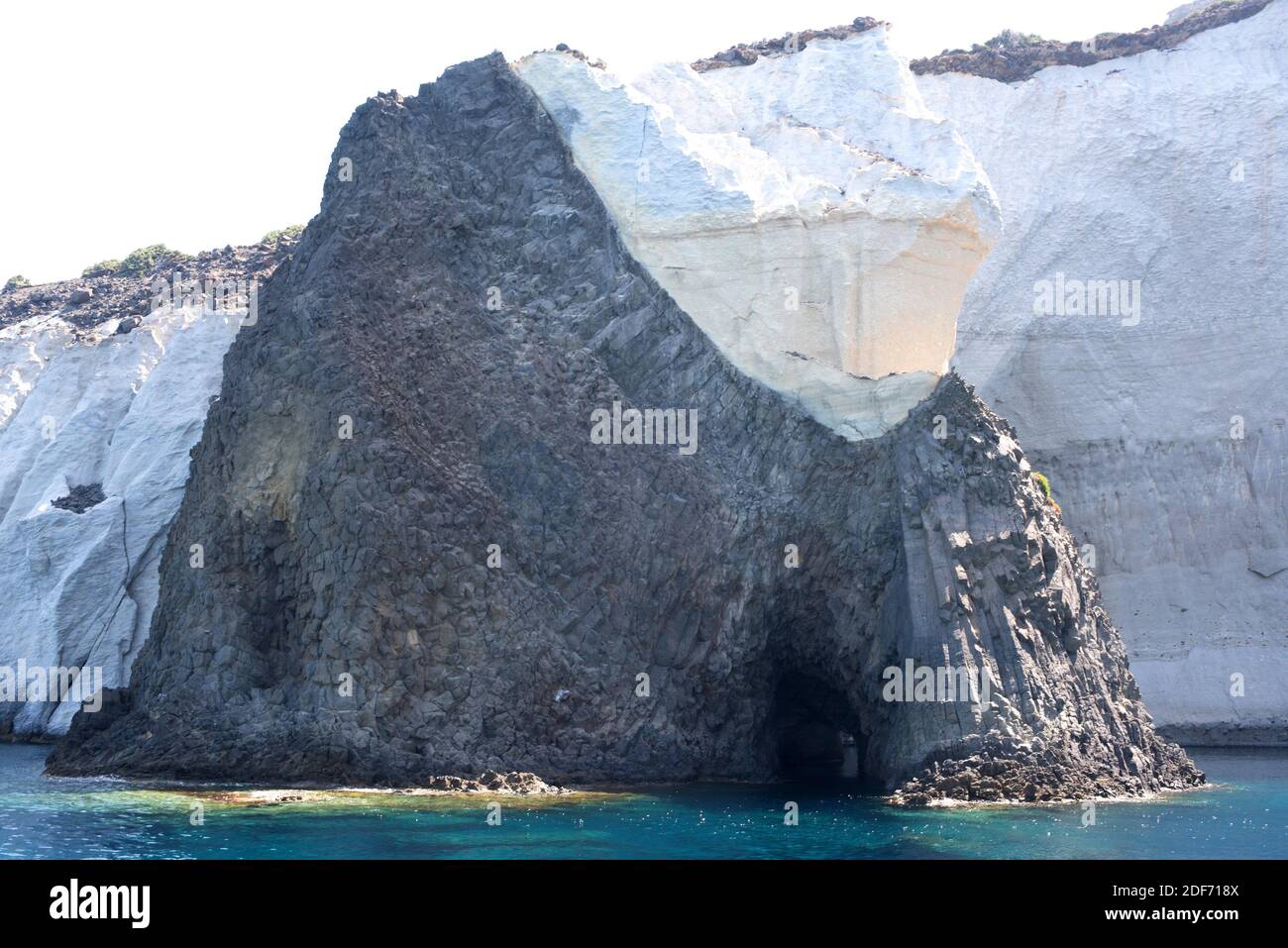 Basalt (black) and tuff (white) two kinds of volcanic rocks. This photo was taken in Milos Island, Greece. Stock Photo