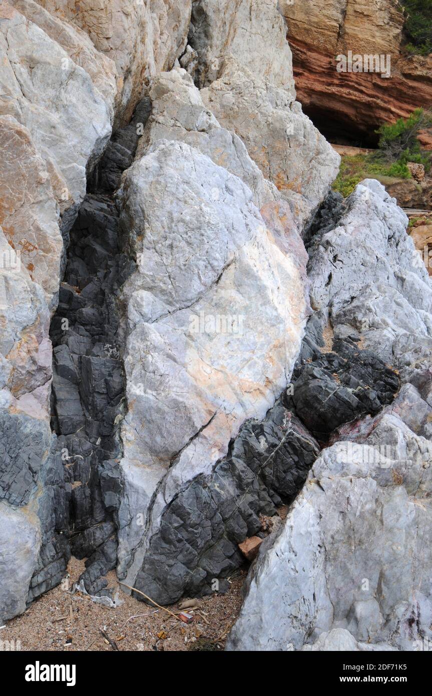 Lamprophyre dikes break through quartz dike. This photo was taken in Costa Brava (Pals), Girona province, Catalonia, Spain. Stock Photo