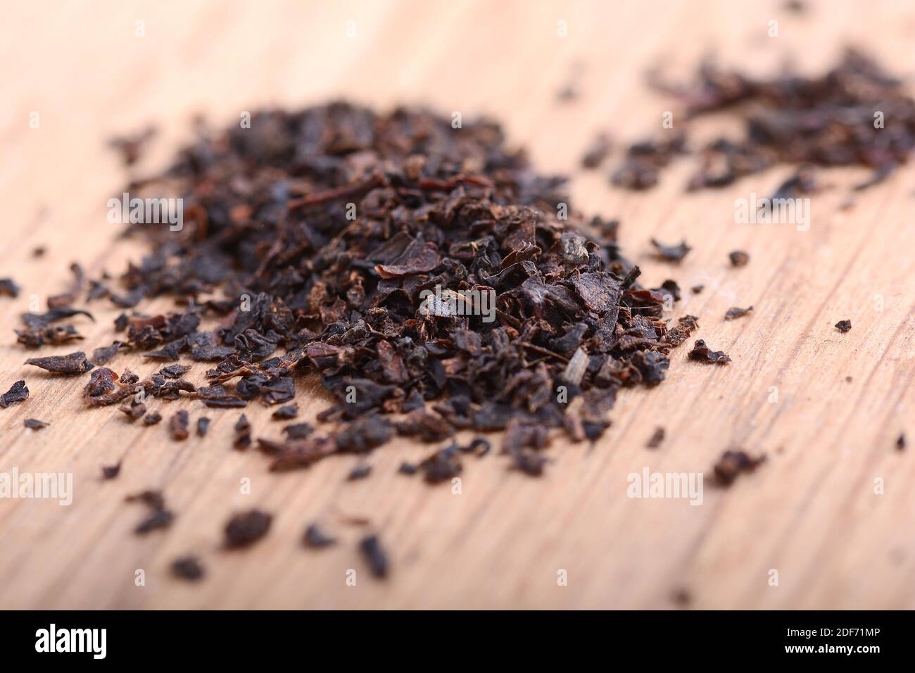 Earl grey black dry tea leaves on wooden plate close up Stock Photo