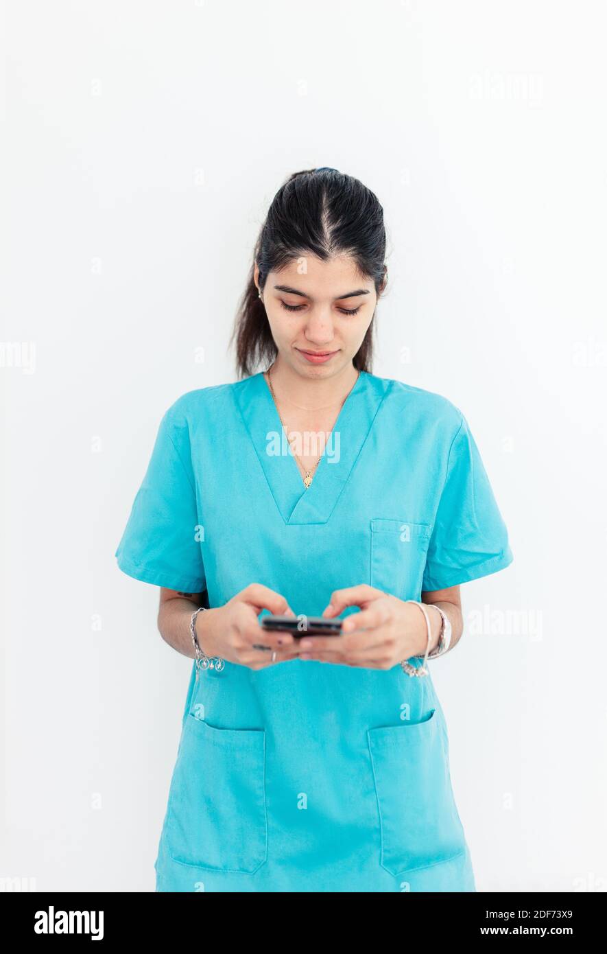 Nurse using smartphone standing in the clinic with withe background Stock Photo