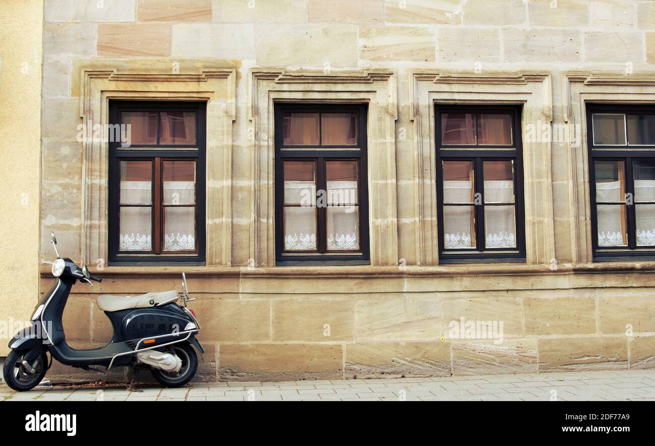 Vintage scooter in front of an old architecture building. Stock Photo