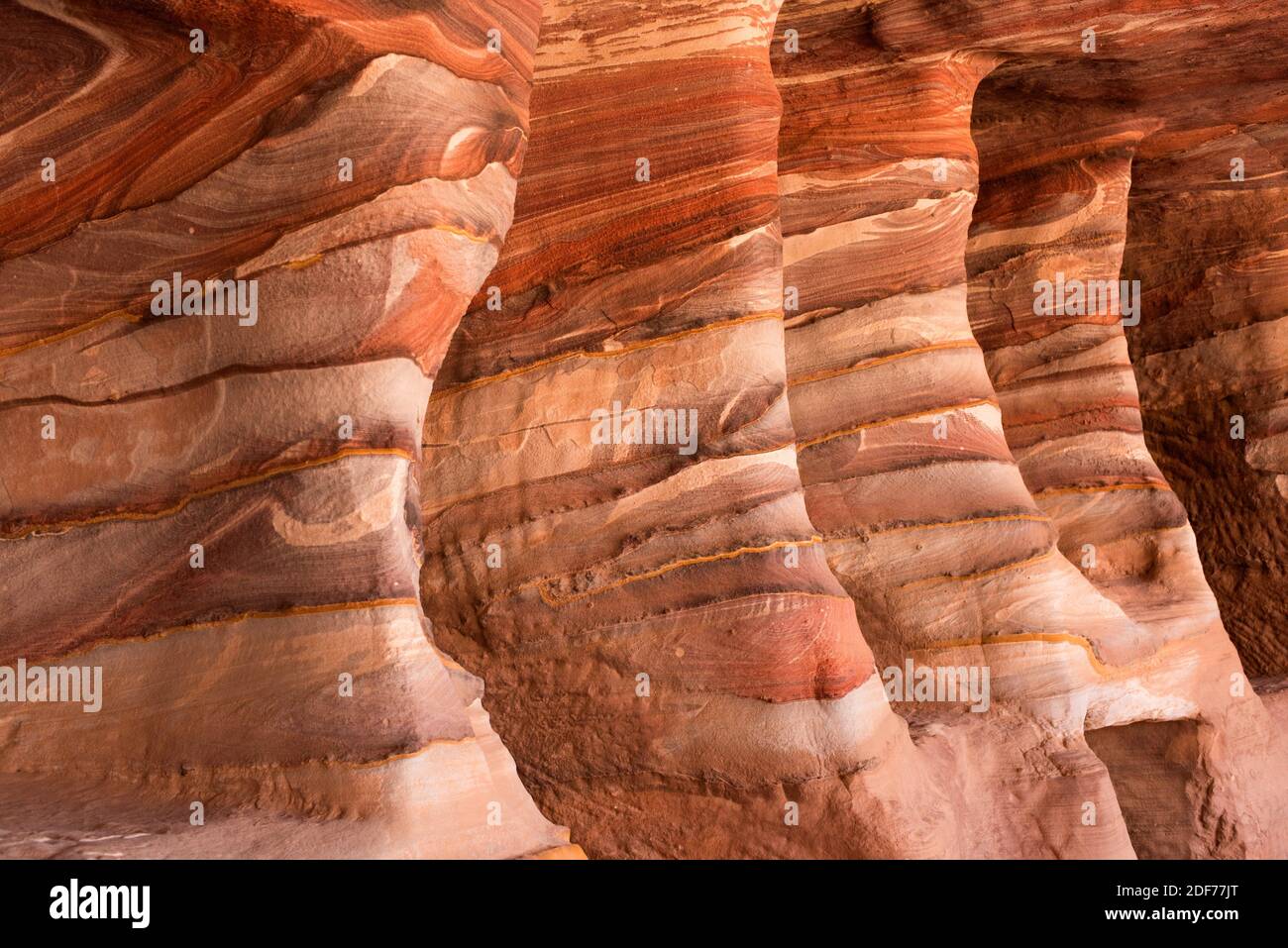 Multicoloured sandstone with cross stratification and Liesegang banding. This photo was taken in Petra, Jordan. Stock Photo