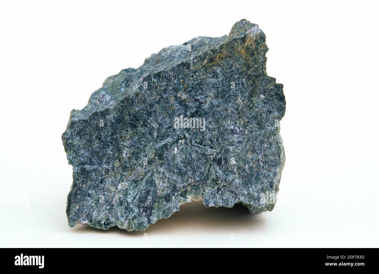 Serpentinite is a metamorphic rock rich on serpentine minerals and formed by metamorphism of ultramafic rocks. Sample. Stock Photo