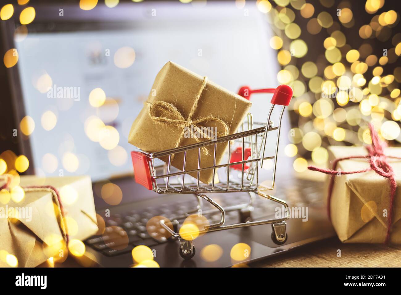 the concept of online shopping. christmas, new year, laptop, trolley with gift, lights Stock Photo