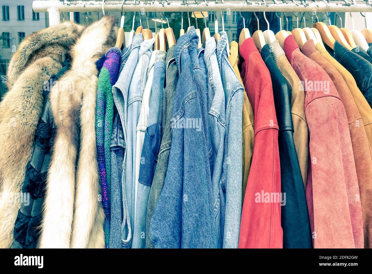 Vintage second hand clothes hanging on shop rack at weekly flea market - Hipster wardrobe sale concept and alternative retro moda fashion styling Stock Photo