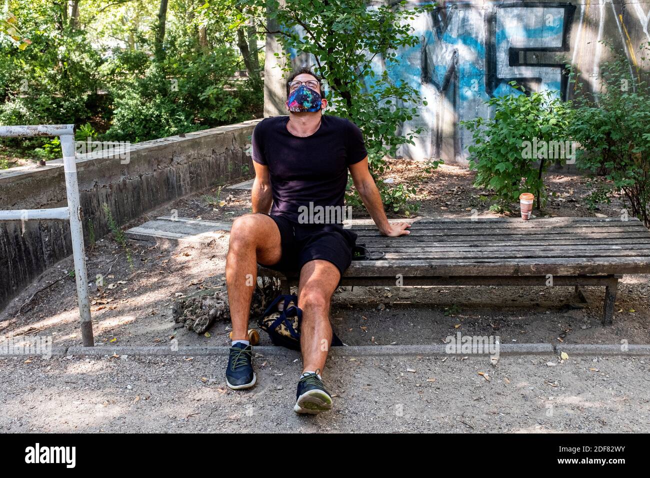 Berlin, Germany. MAture adult gay male wearing a facemask due to Corona  Crisis, catching his breath after a stroll / run through the neighbourhood  Stock Photo - Alamy