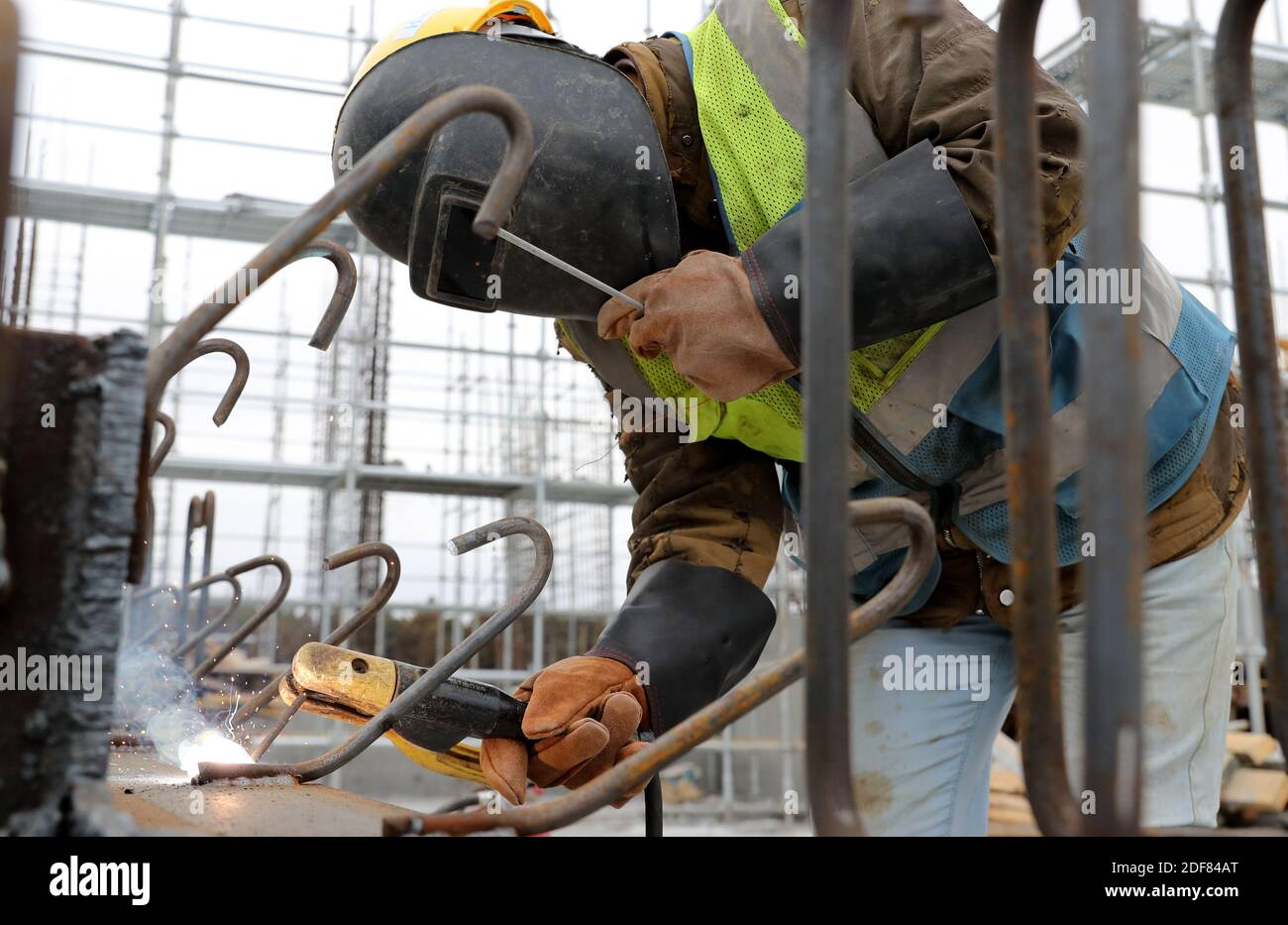 Shanghai. 2nd Dec, 2020. Zhang Xingfa operates a welding gun at a construction site in east China's Shanghai Municipality, Dec. 2, 2020. Zhang Xingfa, 54, is an experienced welder currently working at a construction site in the Lingang Special Area in Shanghai. He accidentally had a first-hand experience with the art of cross-stitch years ago, and could never break away since then. Zhang takes great pleasure in cross-stitch, and sees the similarity between his hobby and his profession - they both command a lot of patience and precision. Credit: Fang Zhe/Xinhua/Alamy Live News Stock Photo