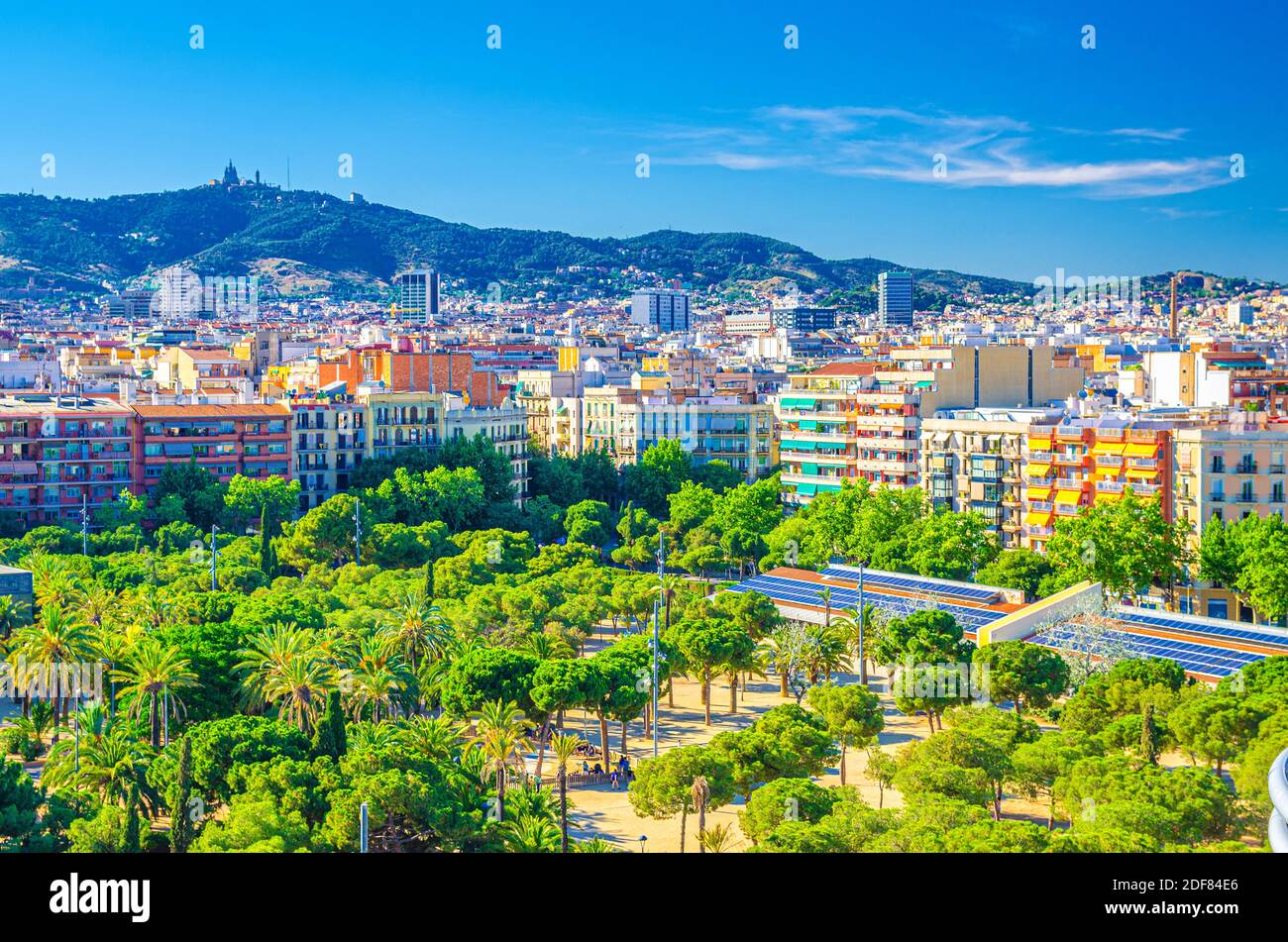 Aerial view of Barcelona city historical quarters districts with palm trees park, residential buildings, Tibidabo hill of Serra de Collserola mountain Stock Photo