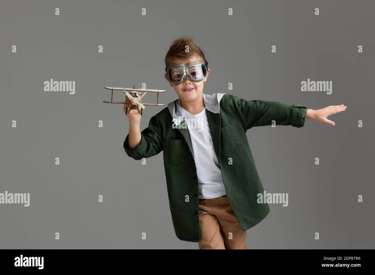 happy child boy in retro glasses playing with wooden toy airplane on ...