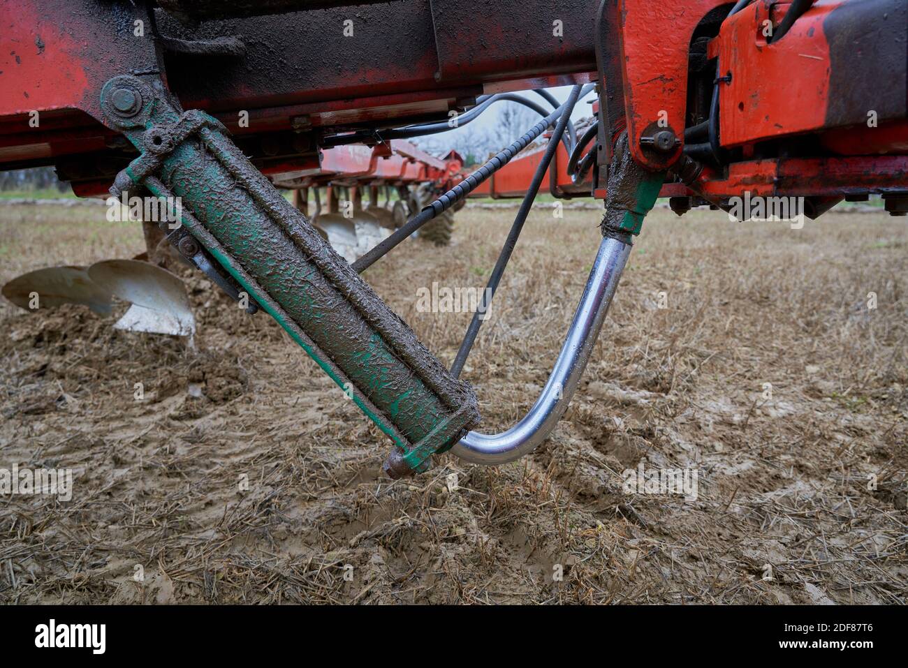A severely damaged bent hydraulic turnover ram on an piece of agricultural farm machinery rendering it inoperable and in need of repair Stock Photo