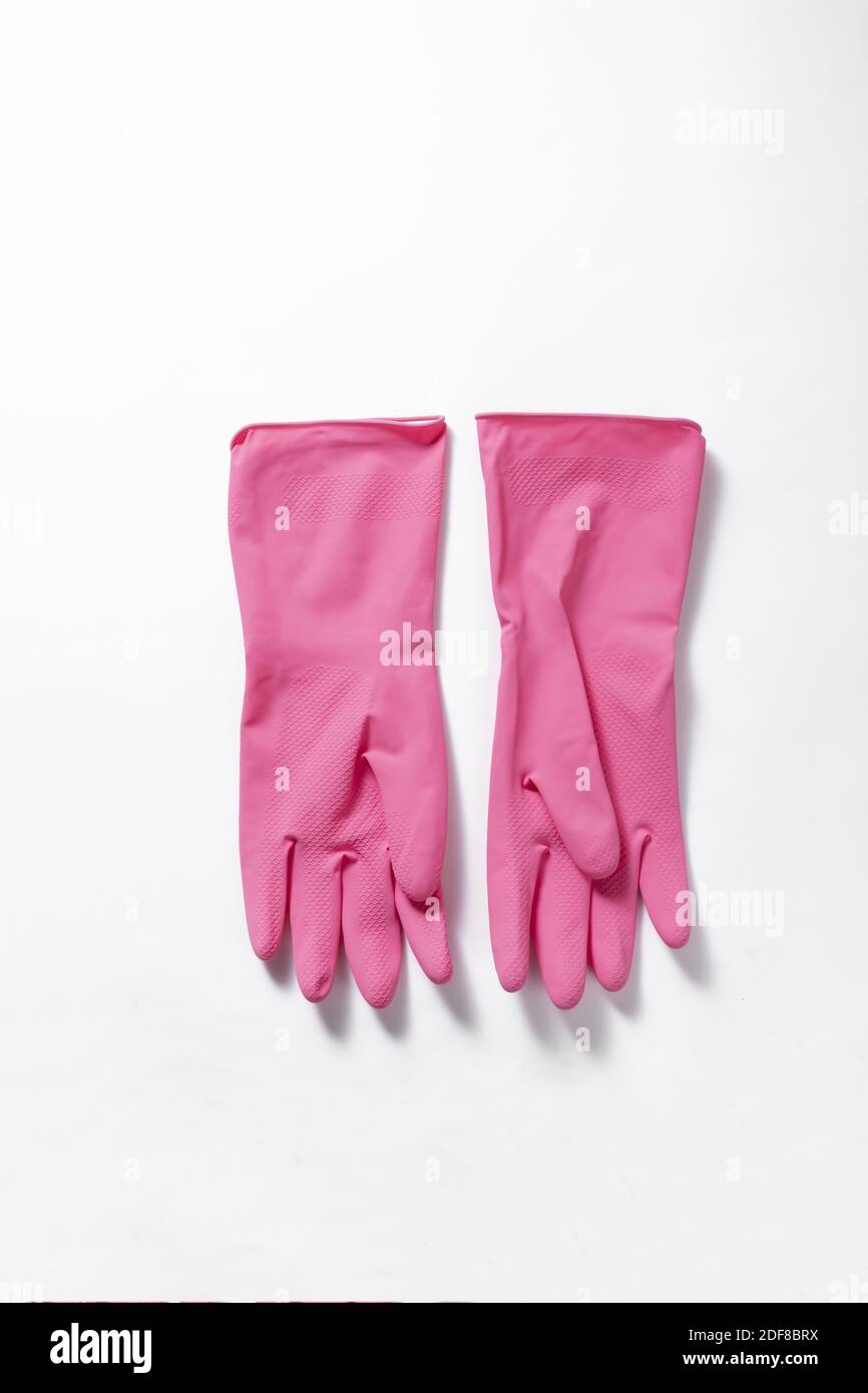 An isolated vertical closeup of pink rubber gloves on a white