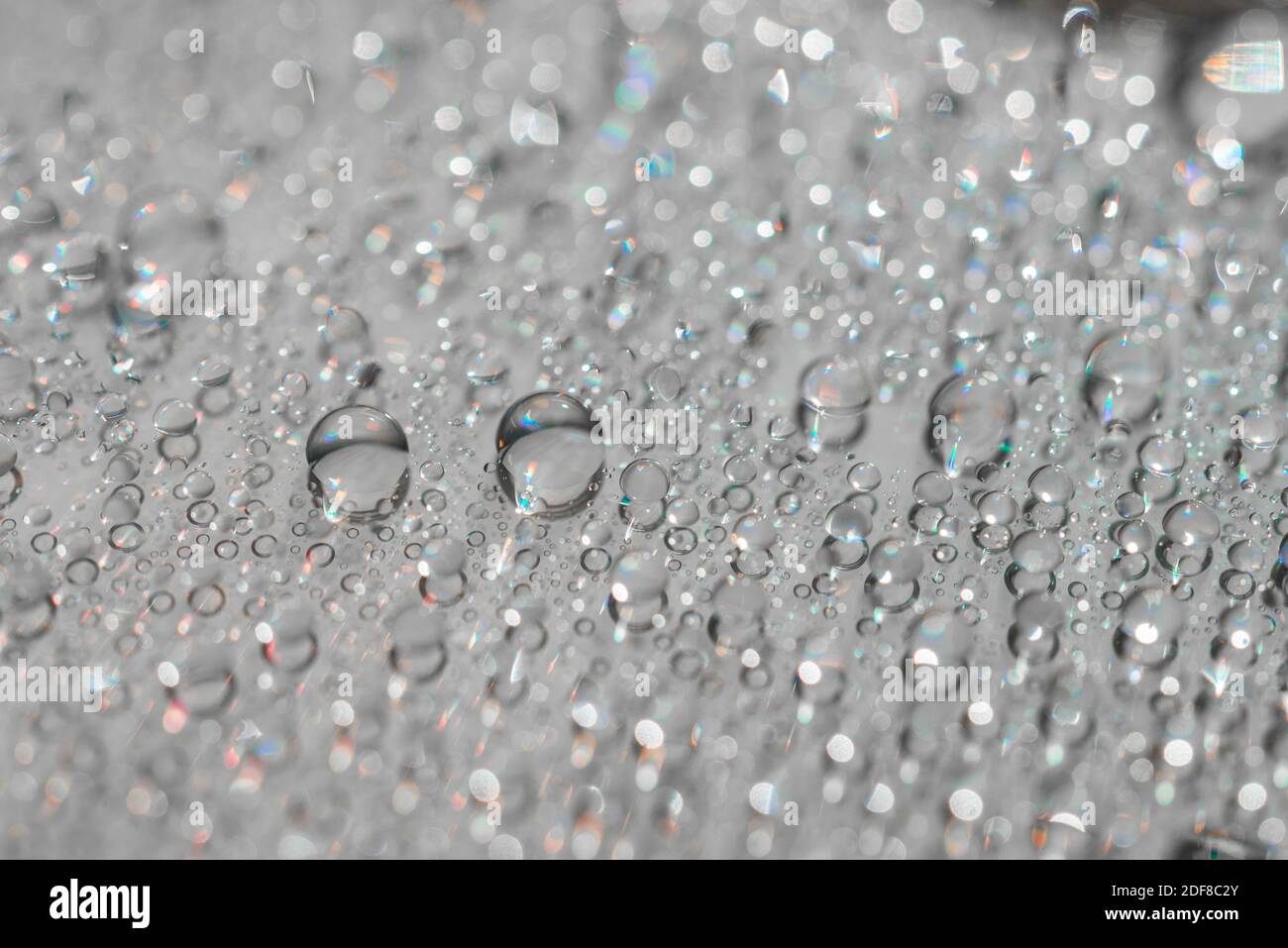 Macro photography of water drops on a mirror reflective surface. Stock Photo
