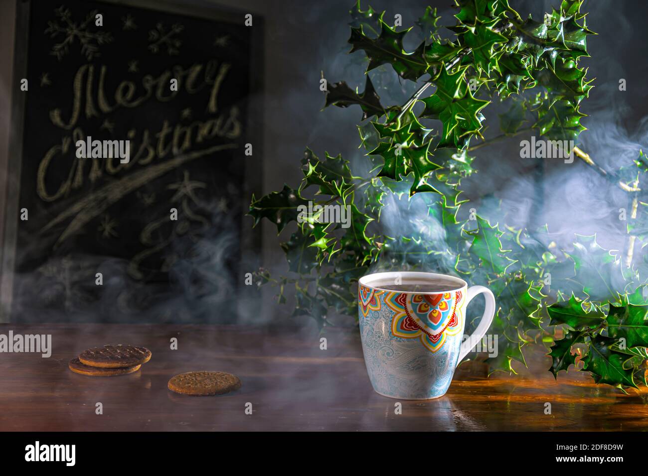 Christmas rustic table with steaming cups of tea, cookies and decorations Stock Photo