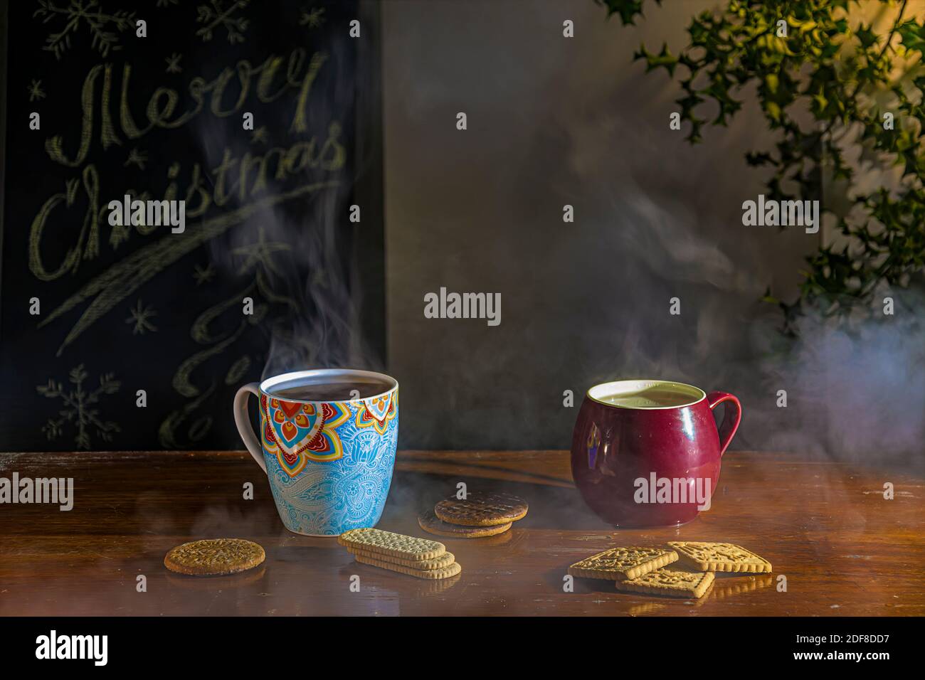 Christmas rustic table with steaming cups of tea, cookies and decorations Stock Photo